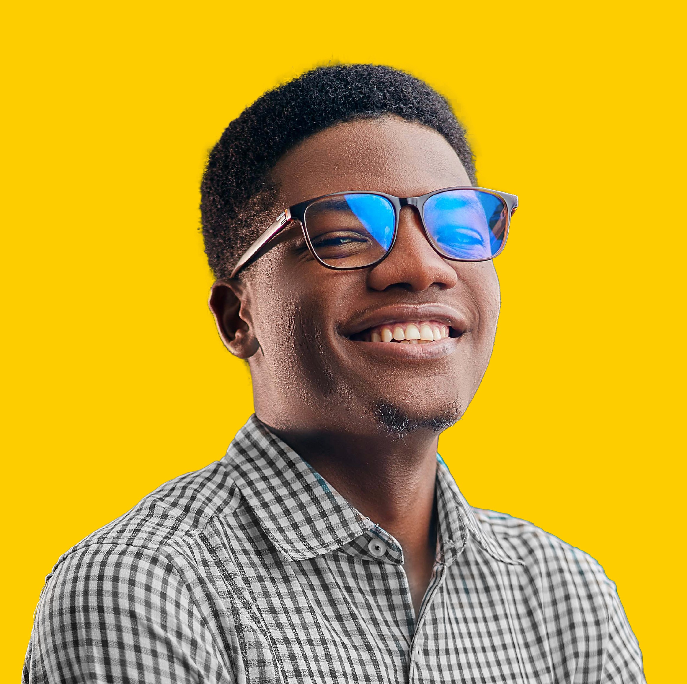 a young man wearing glasses standing in front of a mountain