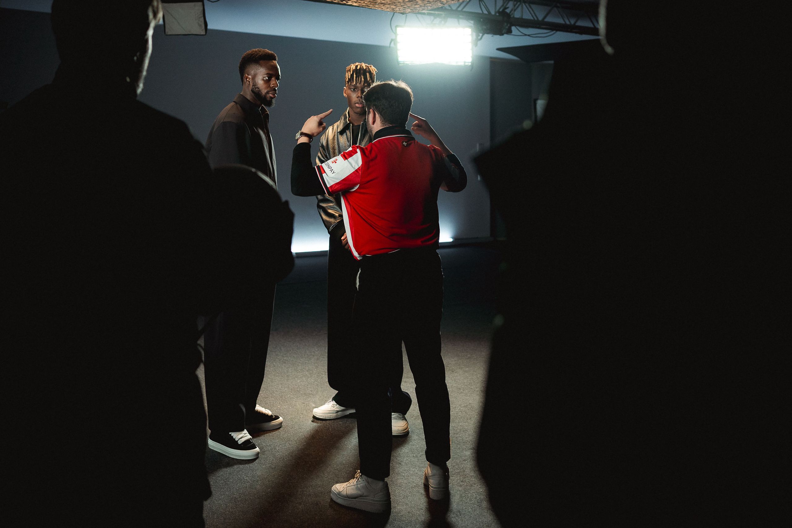 Talent rehearsing a move under a single top light on the For Everybody set