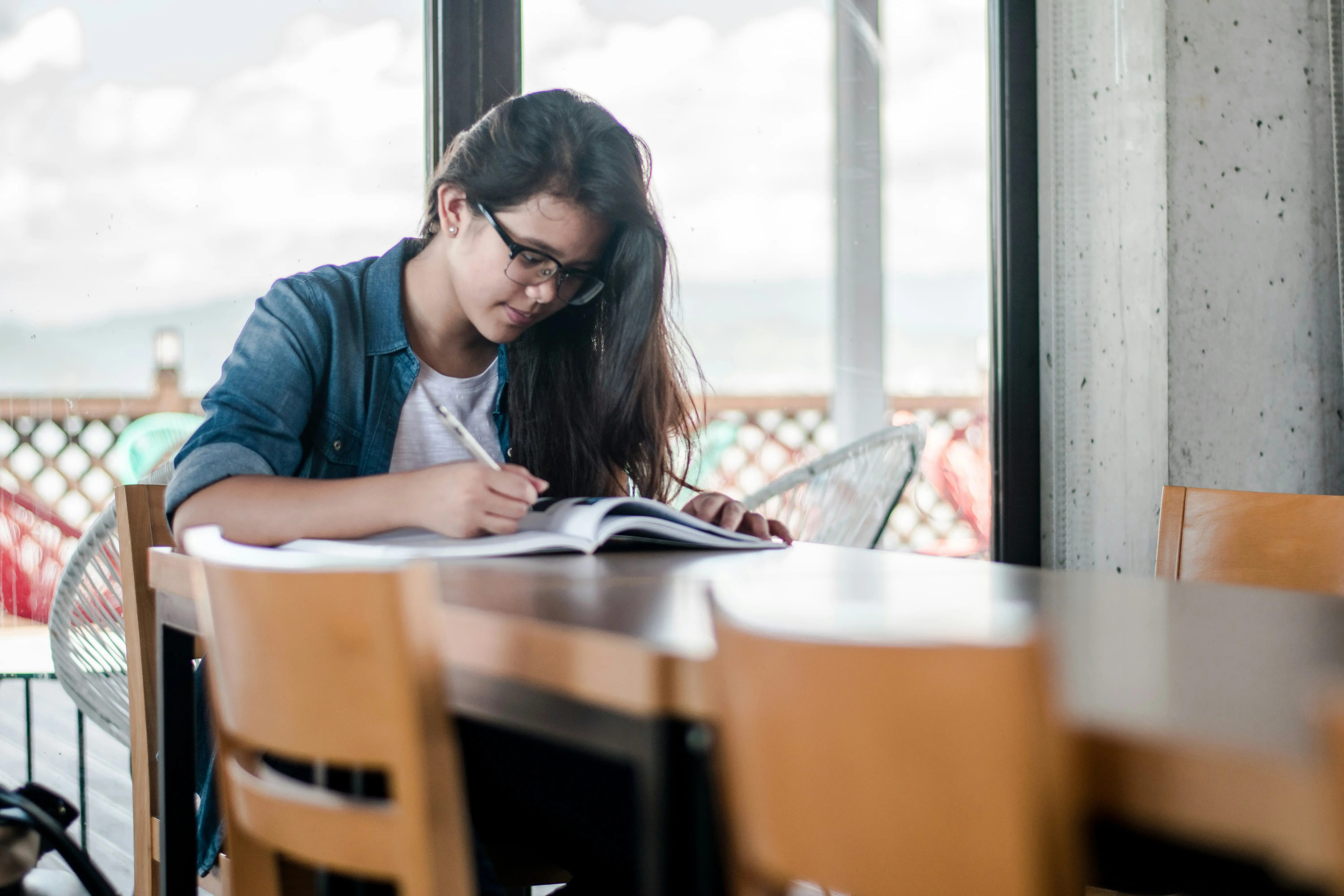 Étudiante travaillant seule à une table avec des livres et un cahier