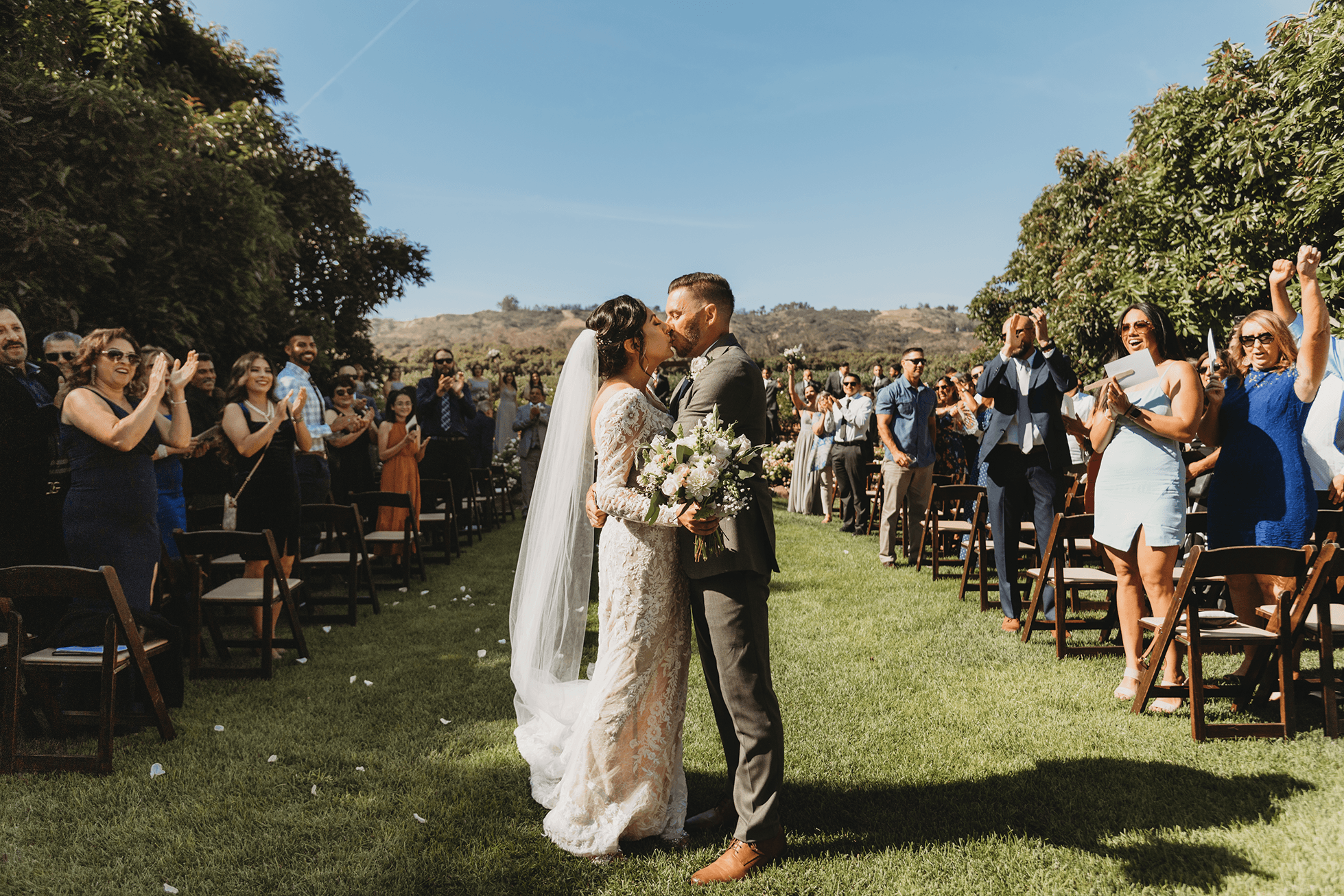 Bride and groom walking down the aisle with guests cheering