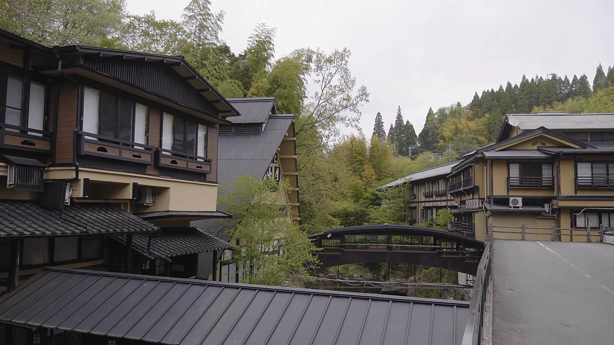 A large inn complex at Kurokawa Onsen stepping down the slope among cedar