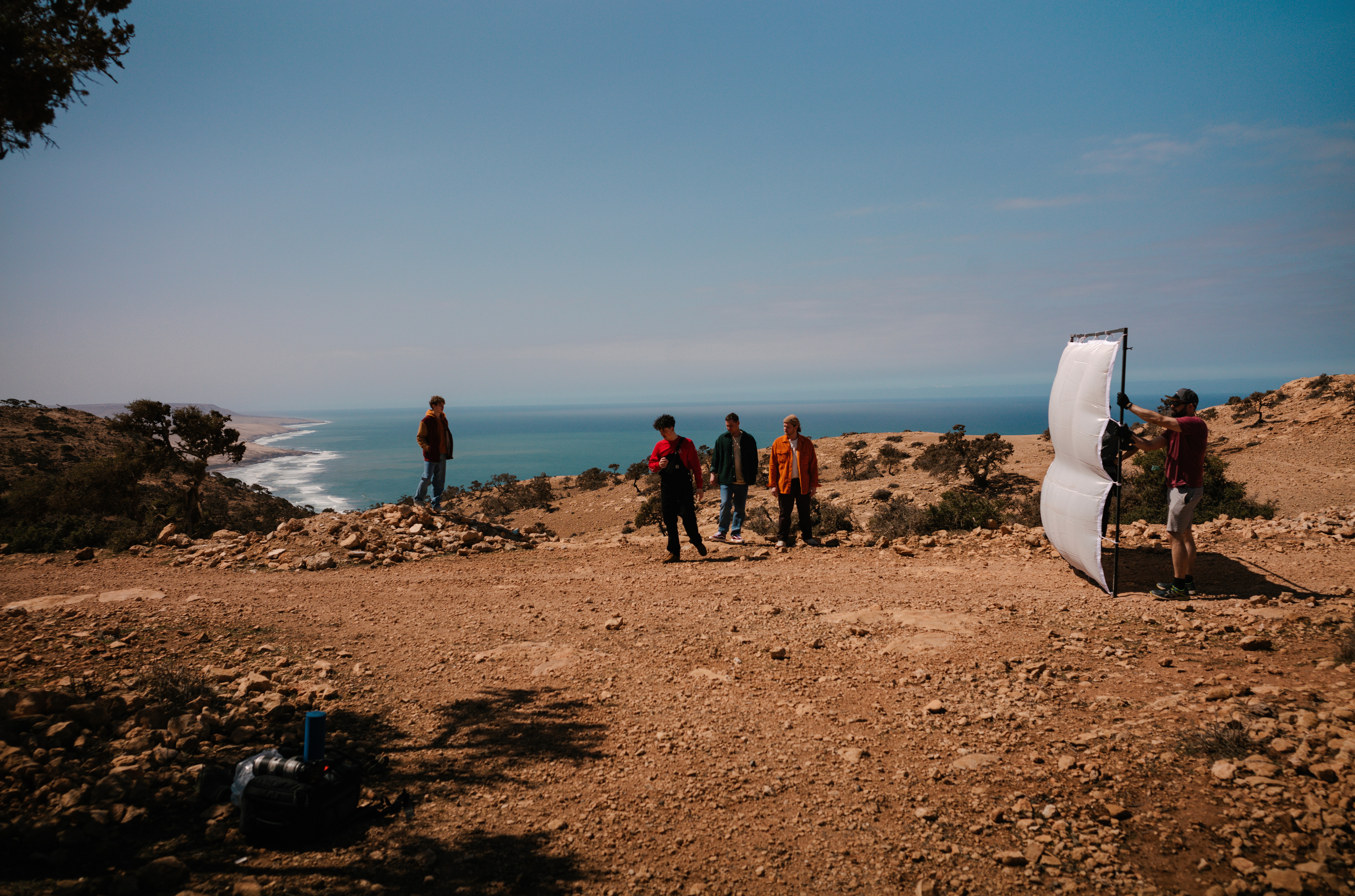Film crew with a reflector shooting on a clifftop above the Moroccan Atlantic coast