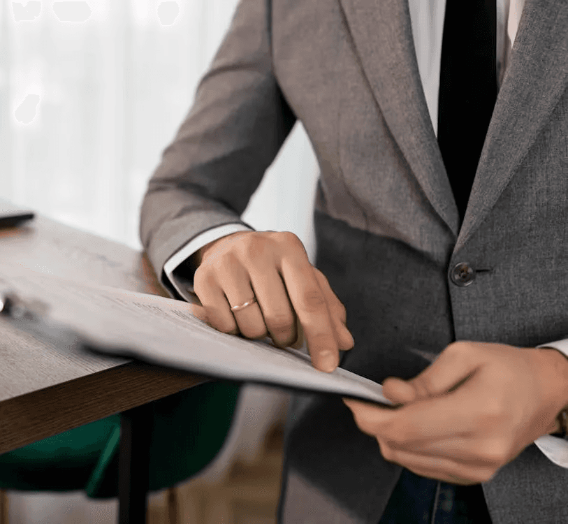 Professional reviewing a job application on a wooden desk.