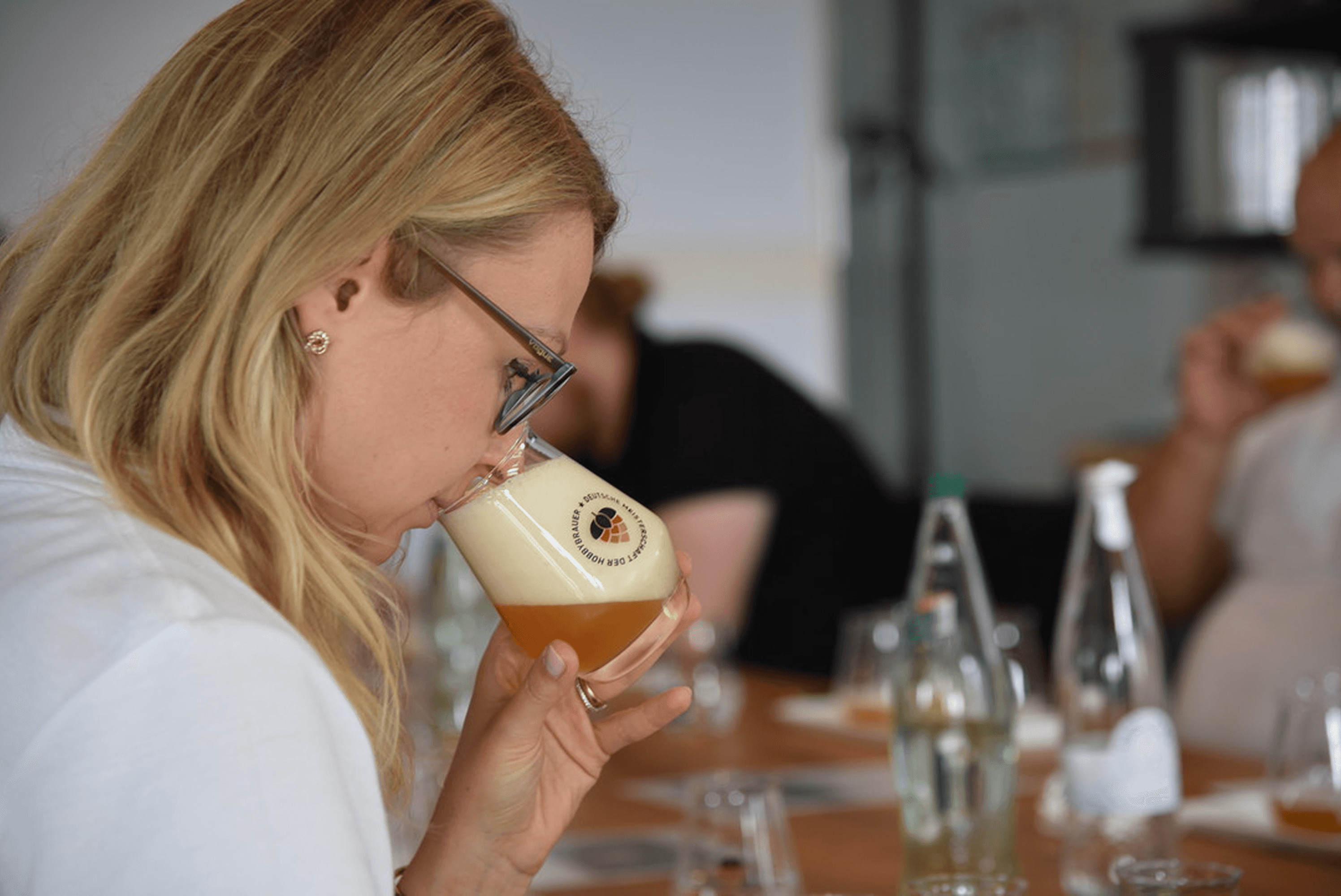 Woman smelling a glass of beer.