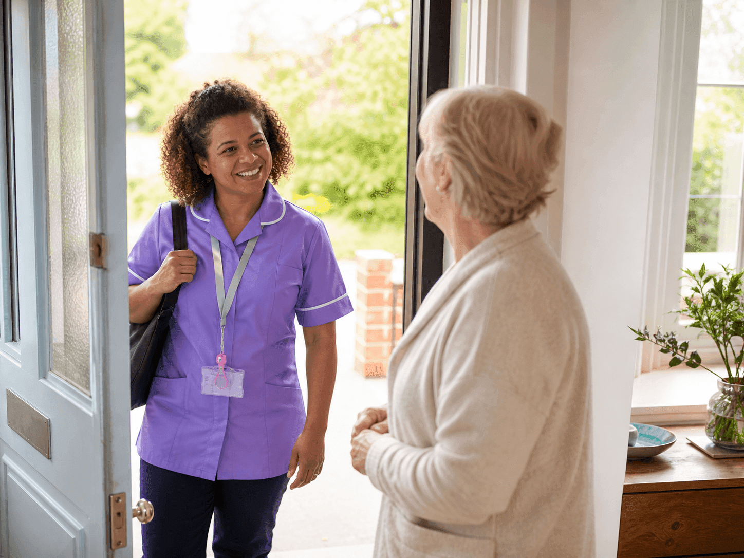 Caregiver speaking with an elderly woman in a calm and welcoming home setting