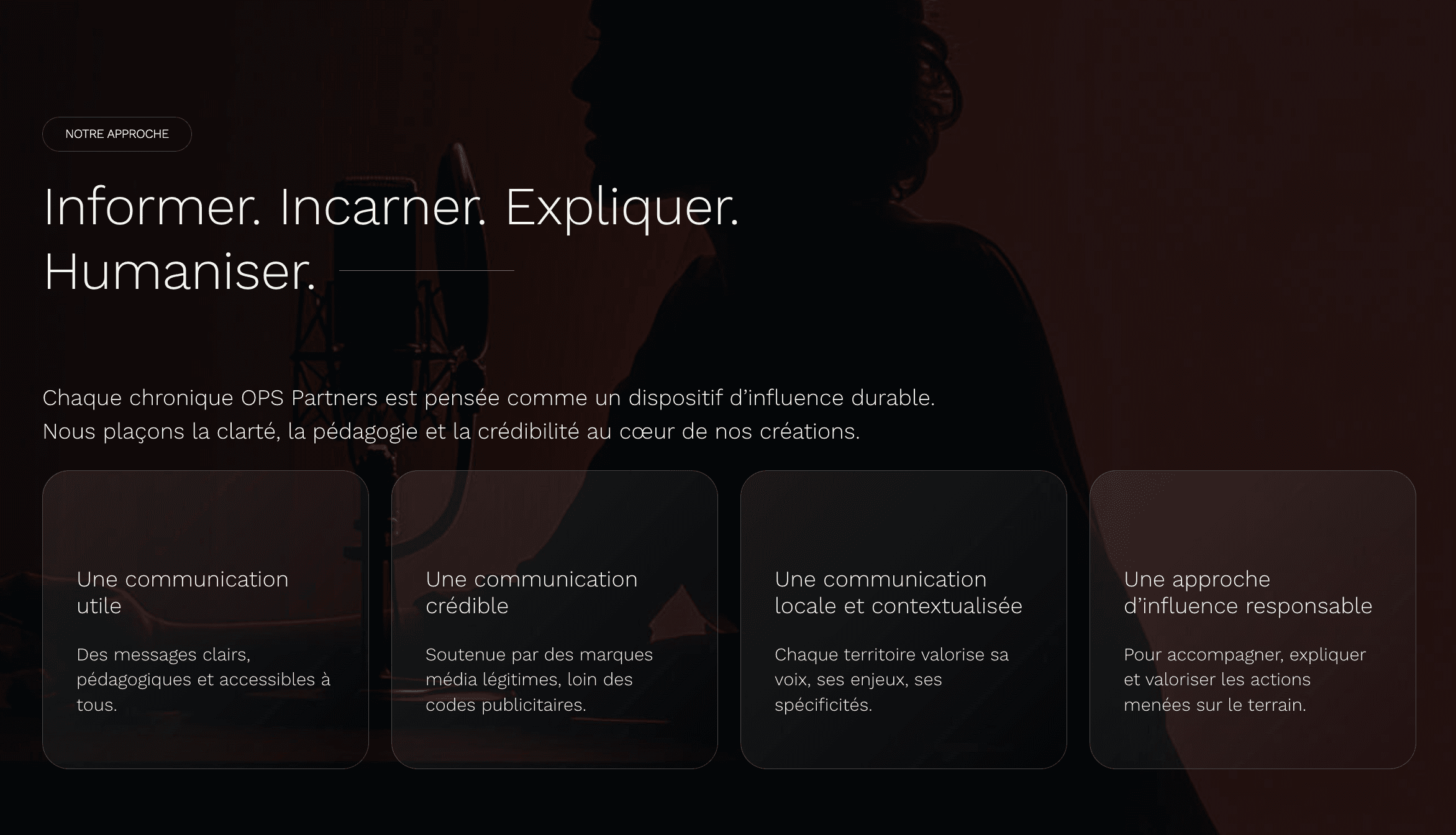 Man in a white shirt reclines in a chair on a red carpet, talking on the phone. Scattered papers surround him, conveying stress or disarray.