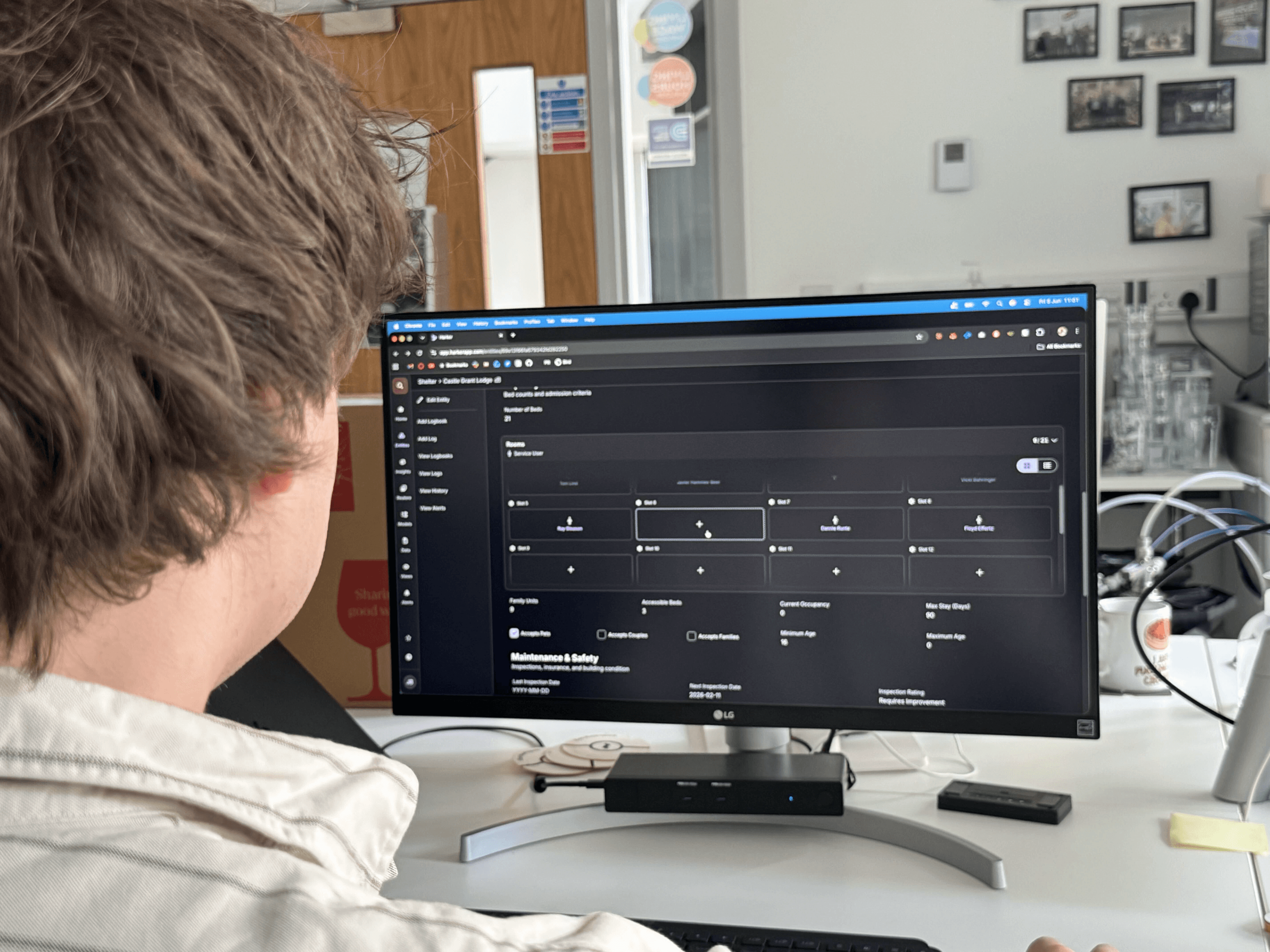 Josh sat at a desk in an office facing a monitor with Harker in a web browser showing Slots.