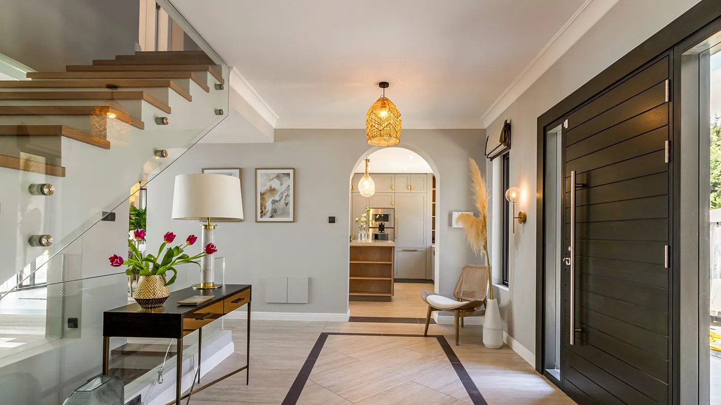 White Cedar House Mediterranean entry hall with floating timber staircase, glass balustrade, and arched doorway