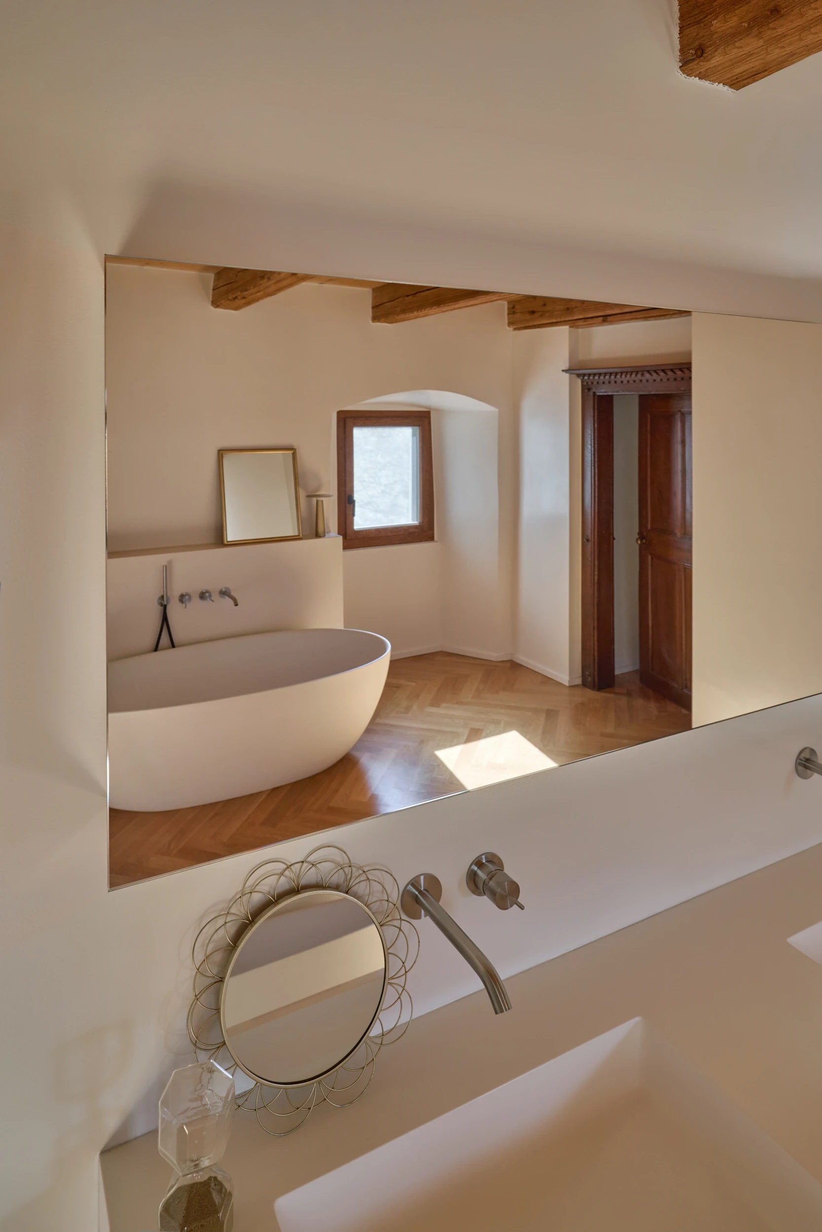 Salle de bain de la maison Muriset à Cully, avec baignoire Boffi, robinetterie CEADESIGN et poutres anciennes conservées dans cet intérieur historique du Lavaux.