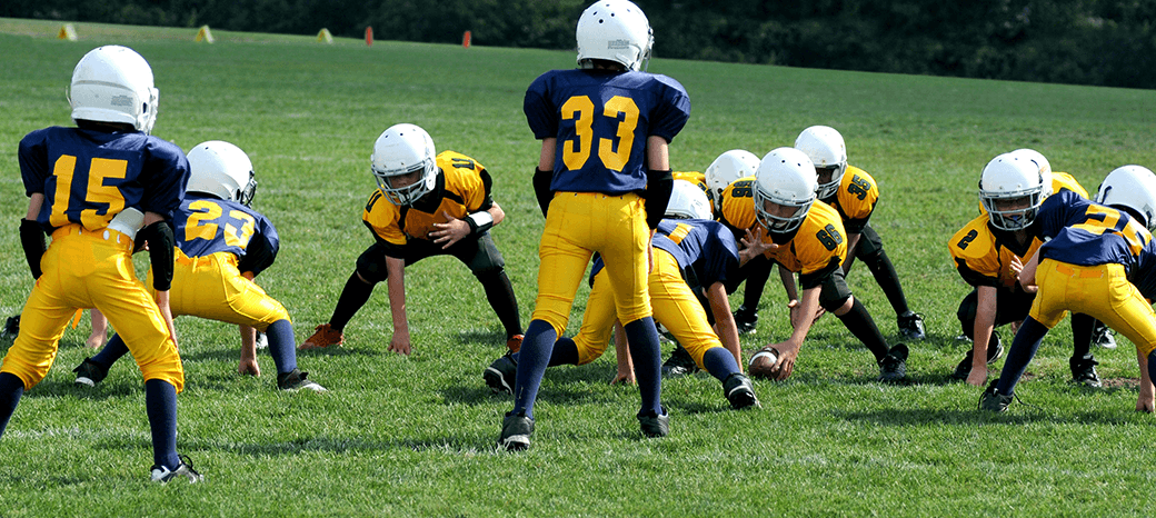 Students practicing passing and catching skills in a structured football enrichment class