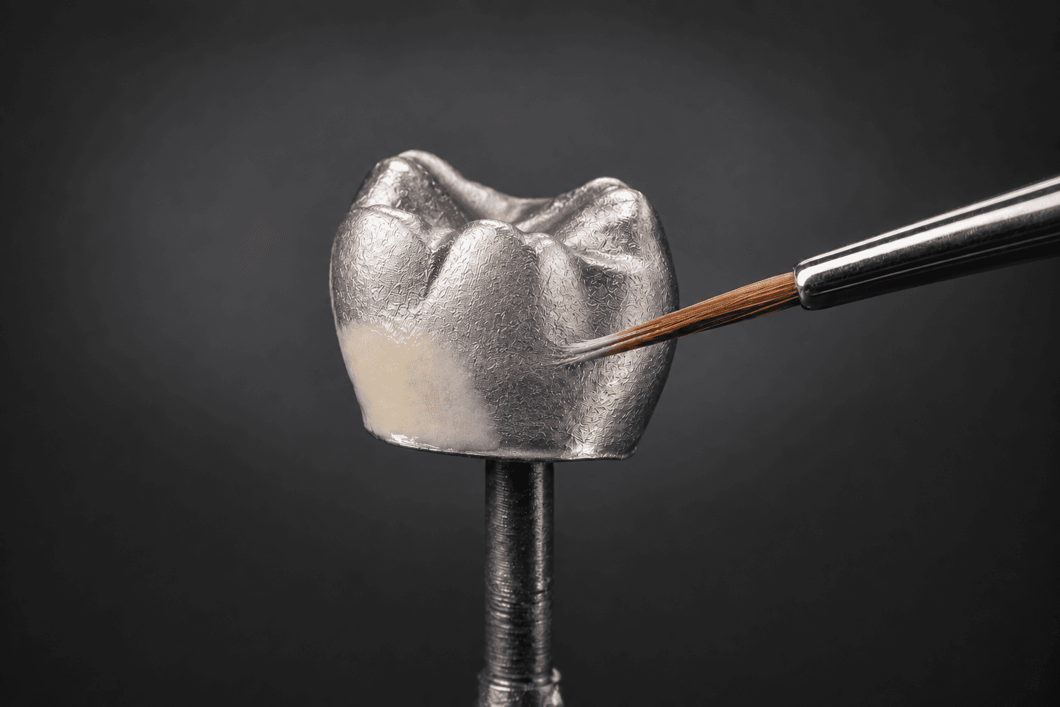 Visualización conceptual de una capa fina y localizada de opacador sobre una cofia metálica. Referencia de la base: Smart Alloy.