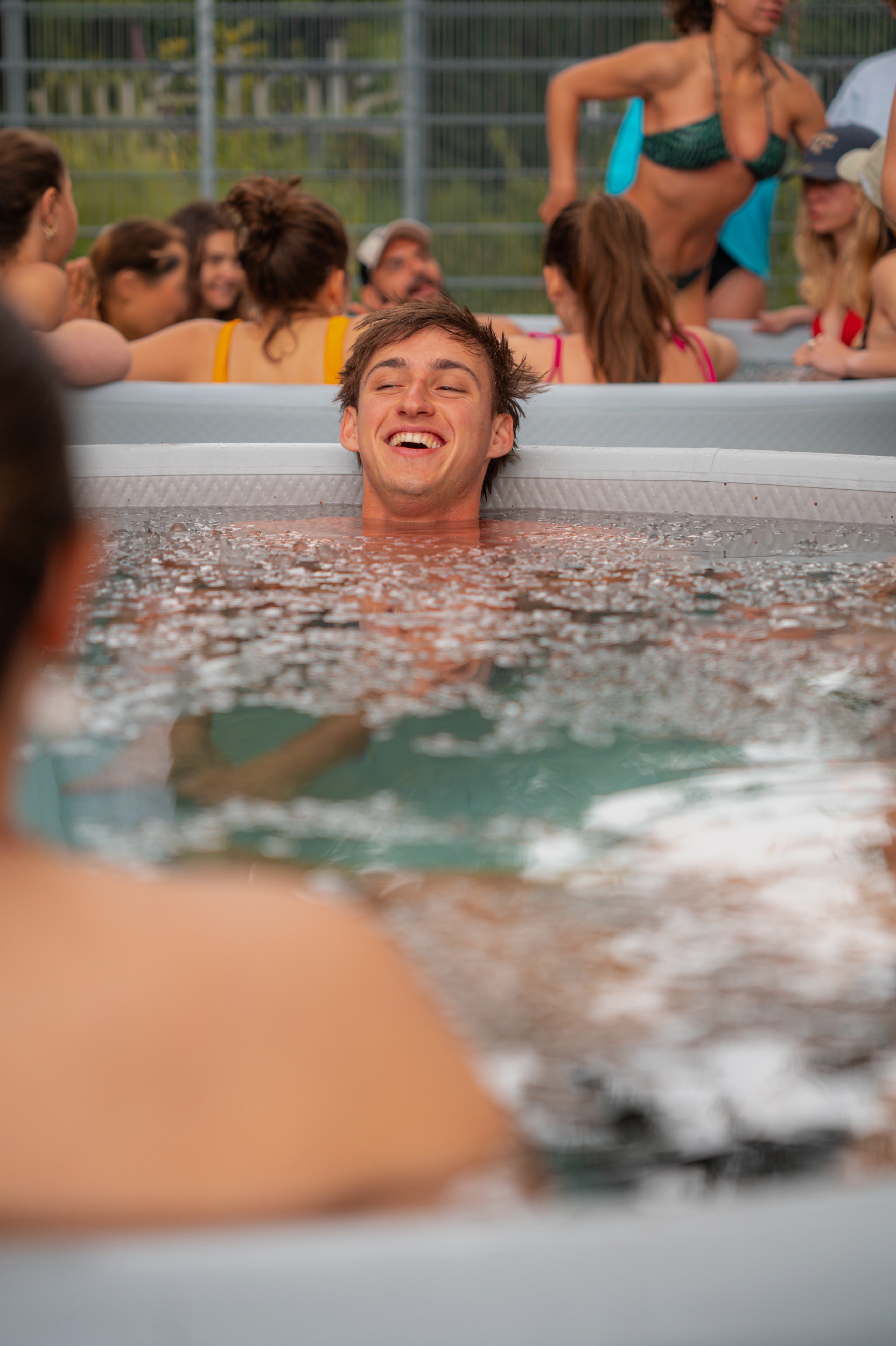 A winding road cuts through rocky terrain, surrounded by patches of green grass and illuminated by sunlight.