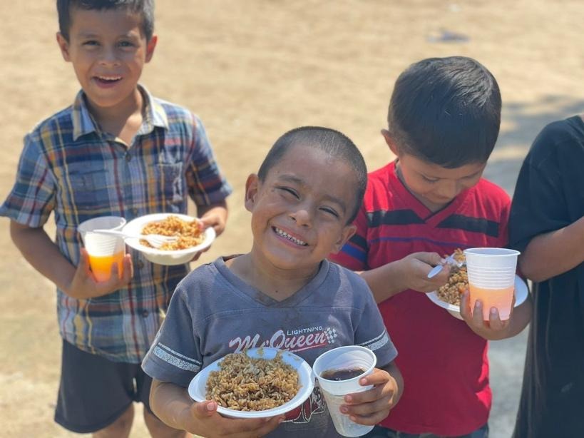 A group of boys holding plates of food

AI-generated content may be incorrect.