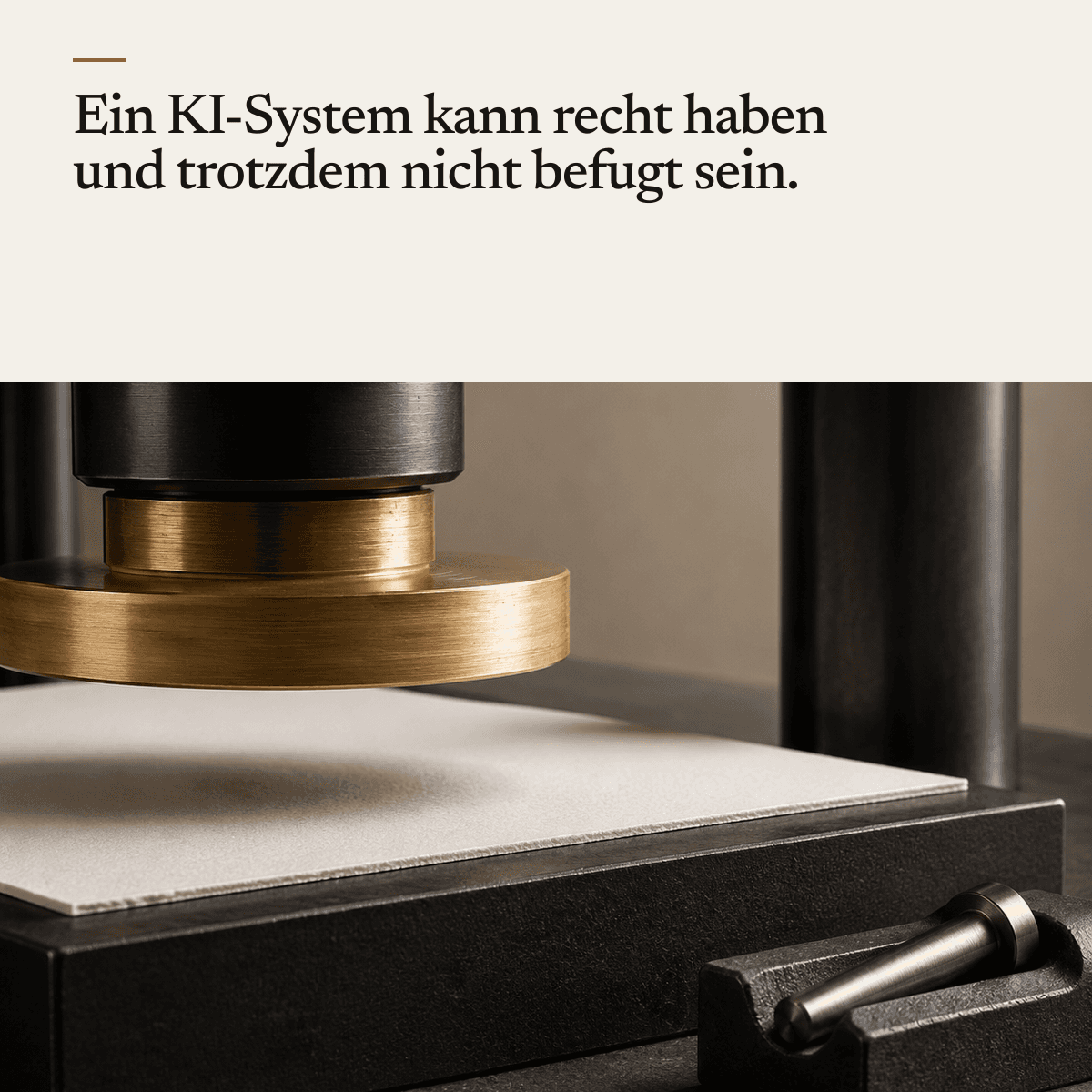 Eine schwere schwarz-messingfarbene Presse schwebt knapp über einem unbedruckten Kartonblatt auf einem dunklen Sockel; der Stempel berührt das Papier nicht ganz.