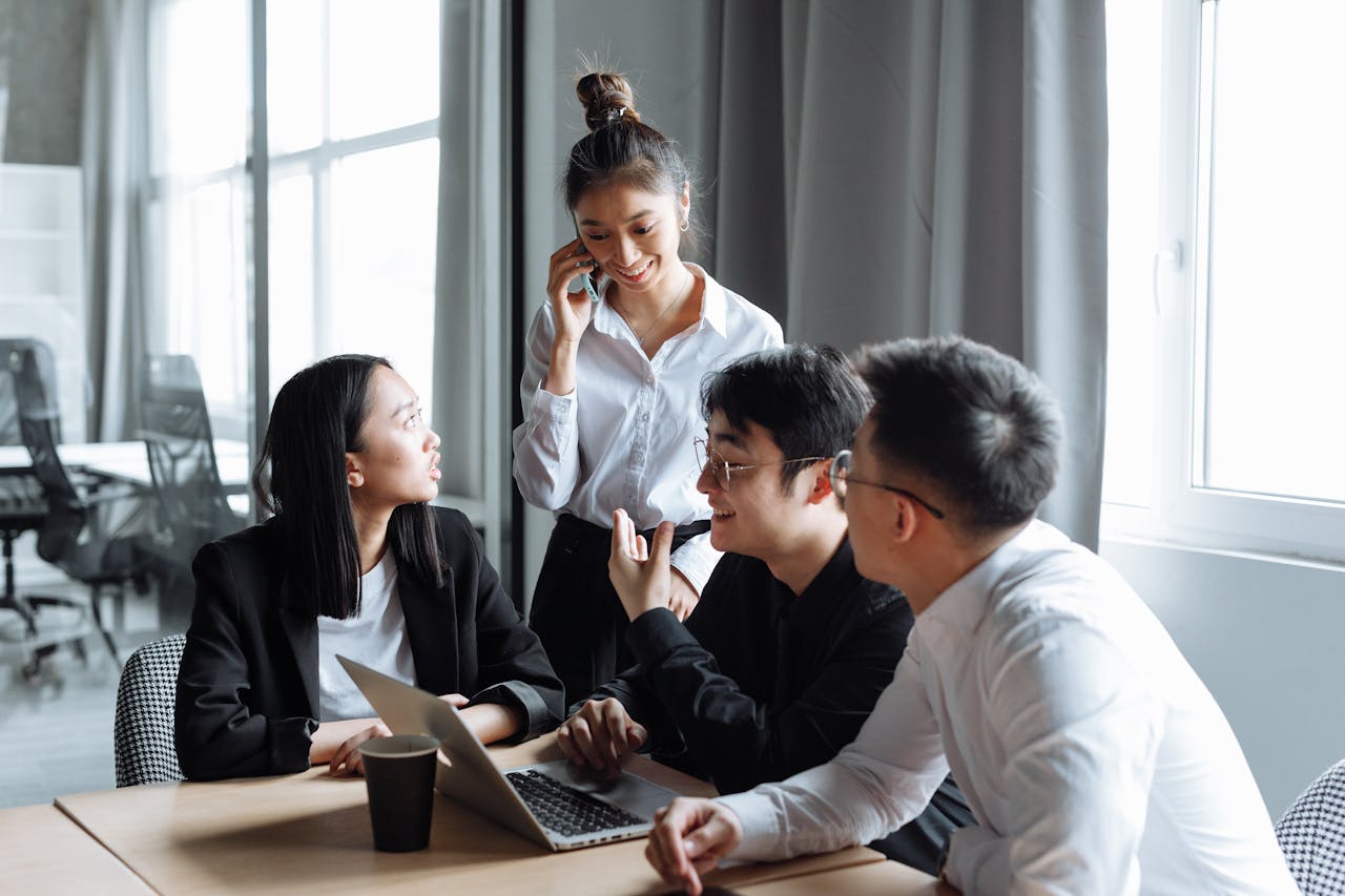 a group of people sitting on chairs with laptop open