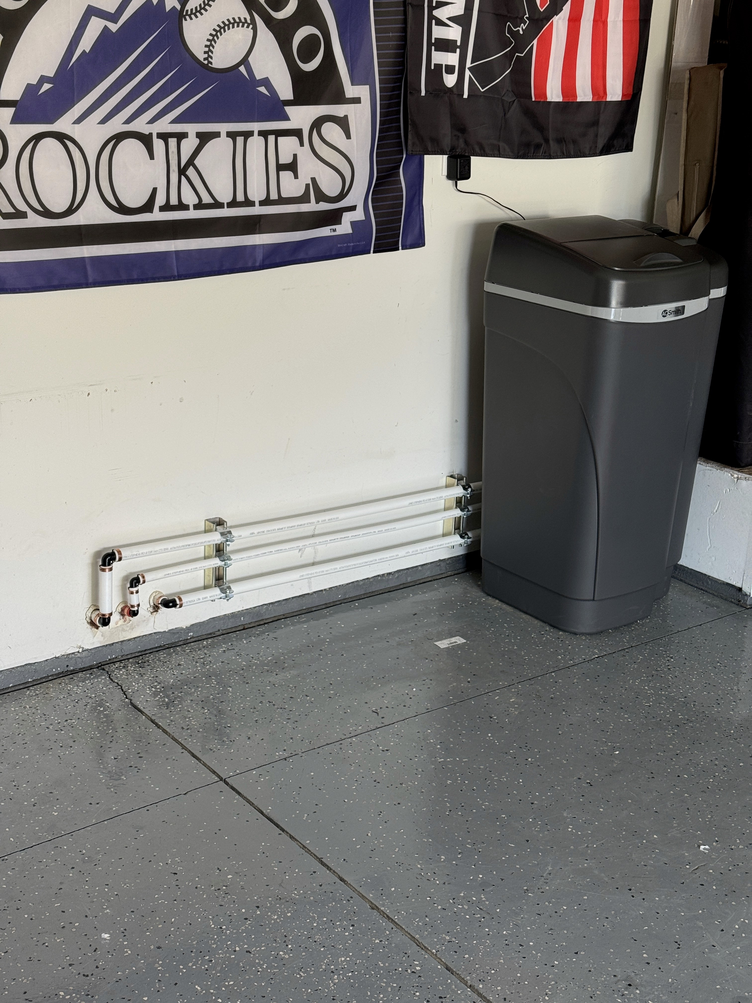 Close-up of a dark green leaf showing its textured surface and central vein against a muted background.