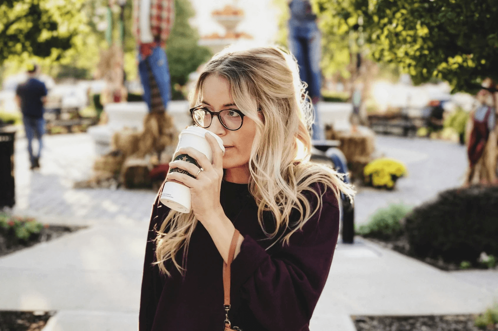 Woman drinking coffee outdoors, representing individual therapy and self-reflection