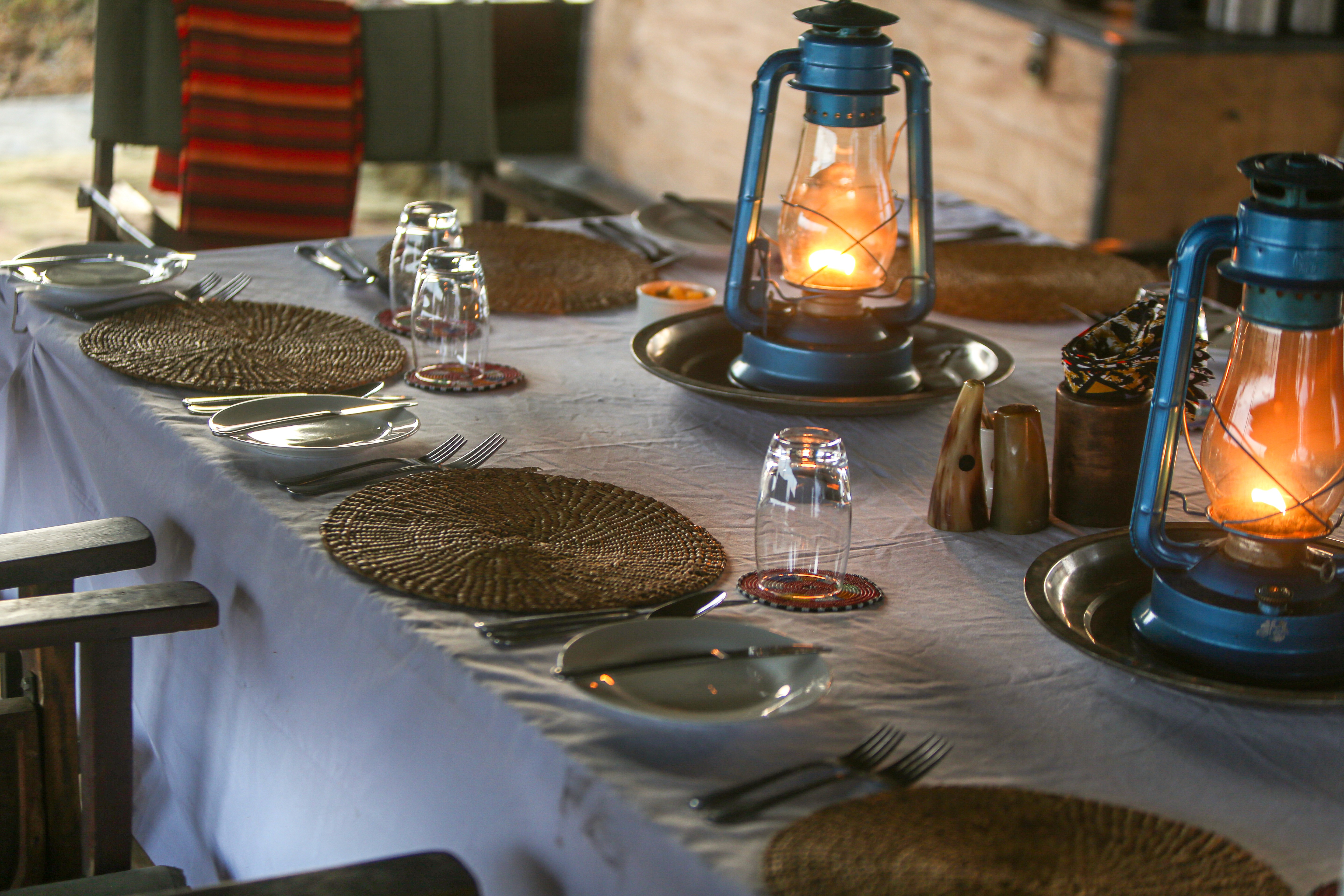 Kilimanjaro Elephant Ride, Arusha, Tanzania. En kvinna sitter och läser utanför ett tält uppsatt i vildmarken.