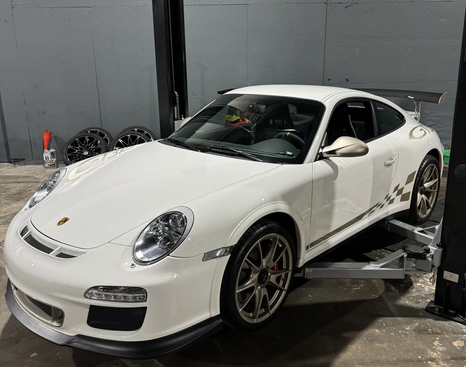 White Porsche 911 GT3 RS on a lift in the 714 Technik service bay