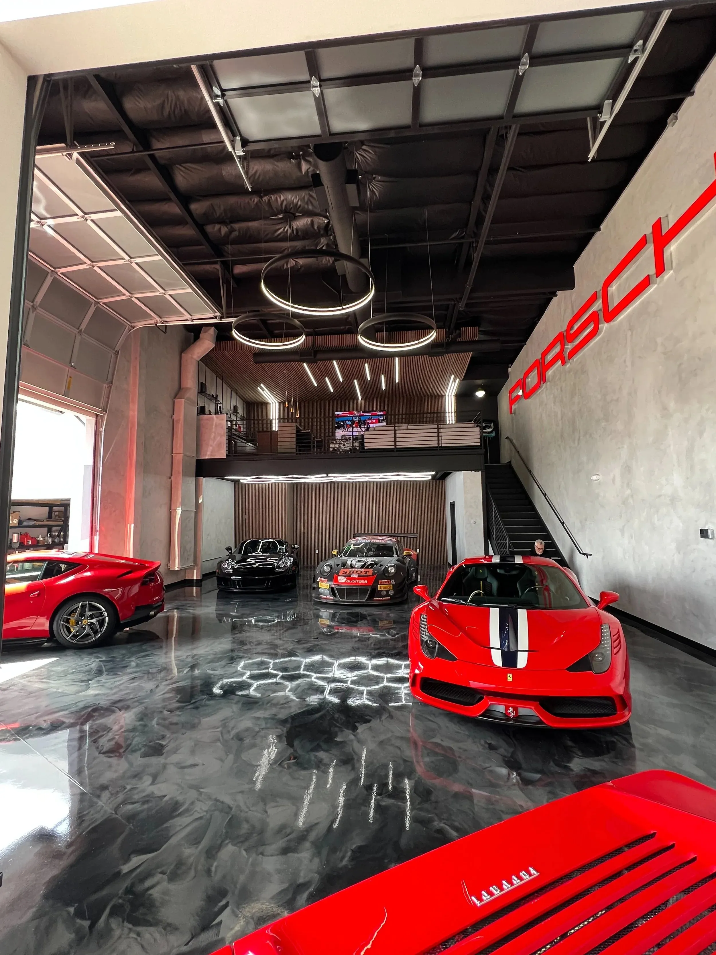 Two men discuss a project while standing at a laptop in an office.