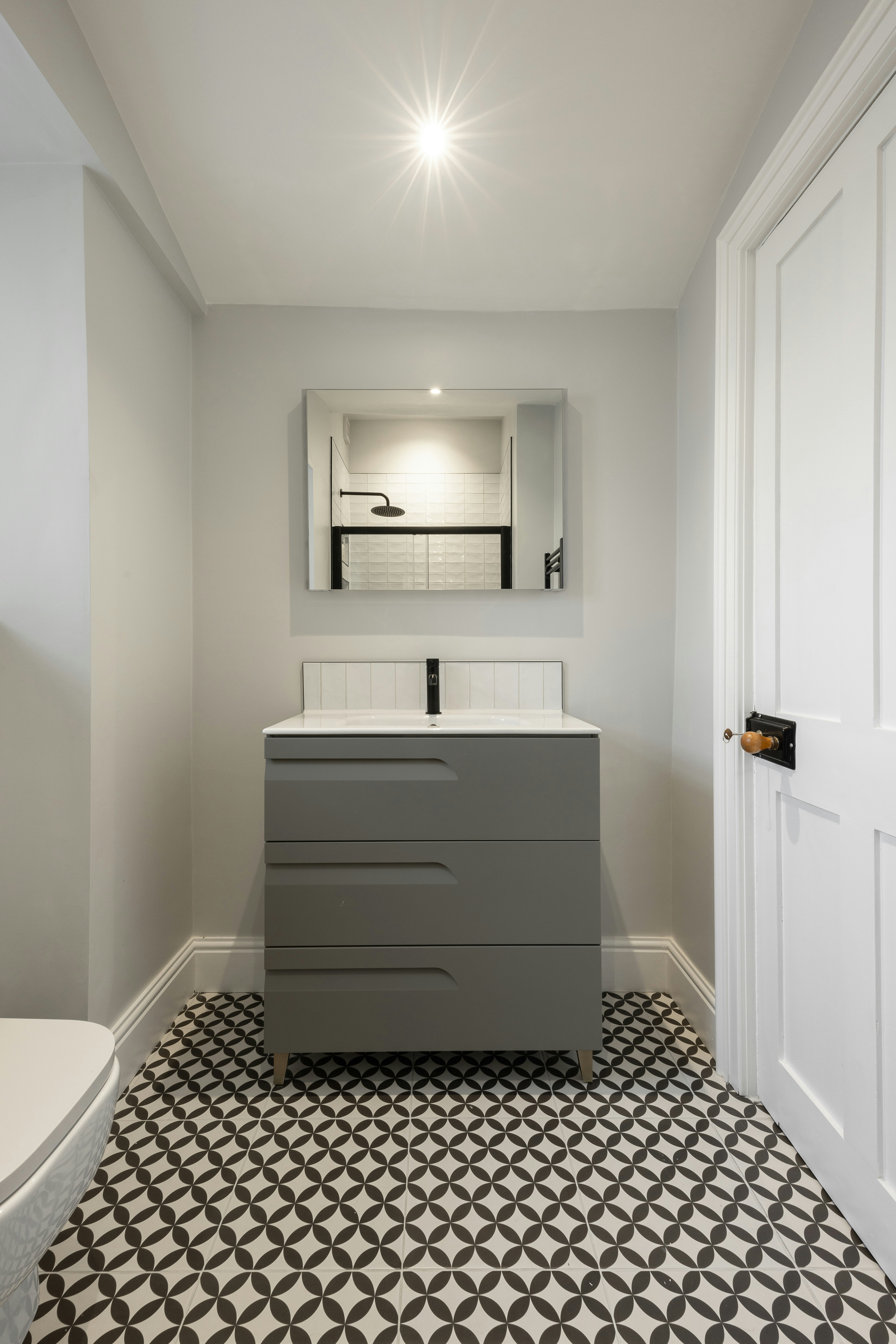 A bathroom with a toilet, sink and mirror