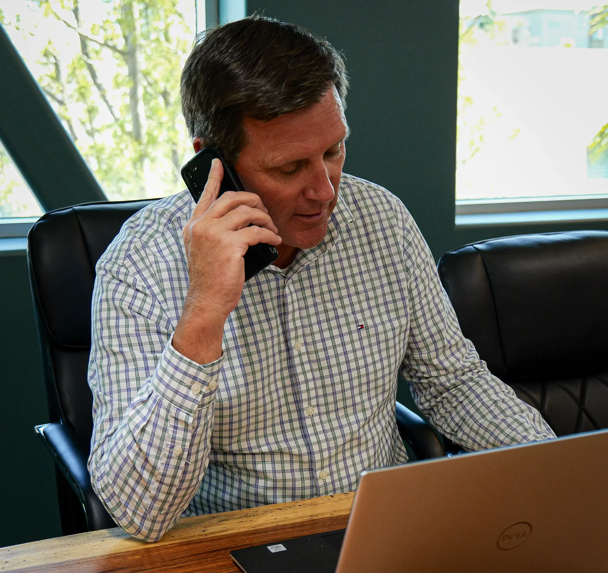 Man in dress clothes talking on phone at desk