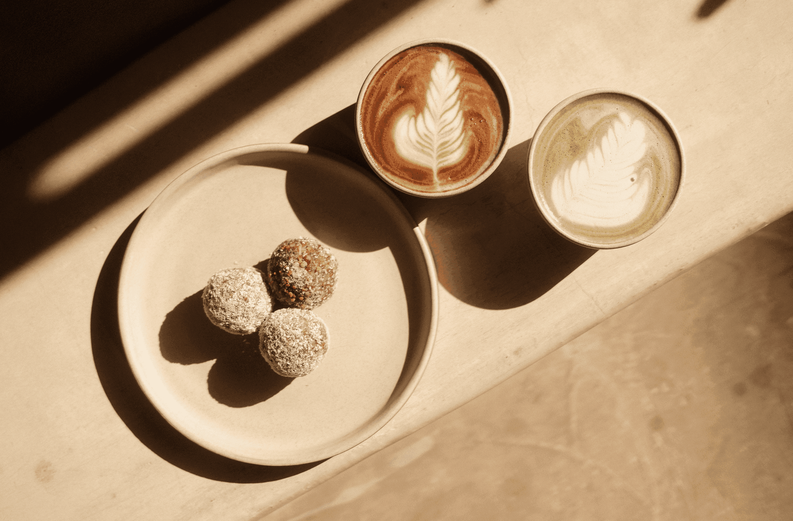 Professionelle Lifestyle- und Werbefotografie im Raum Schwäbisch Gmünd: Stimmungsvolle Detailaufnahme mit Latte Art und Snacks.