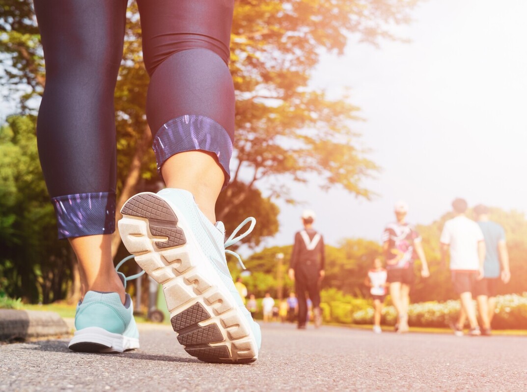 woman walking down a park pathway showing how many steps a day to lose weight effectively