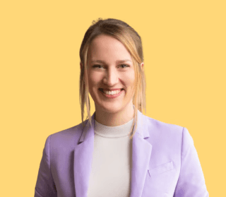 Close-up of a dark green leaf showing its textured surface and central vein against a muted background.