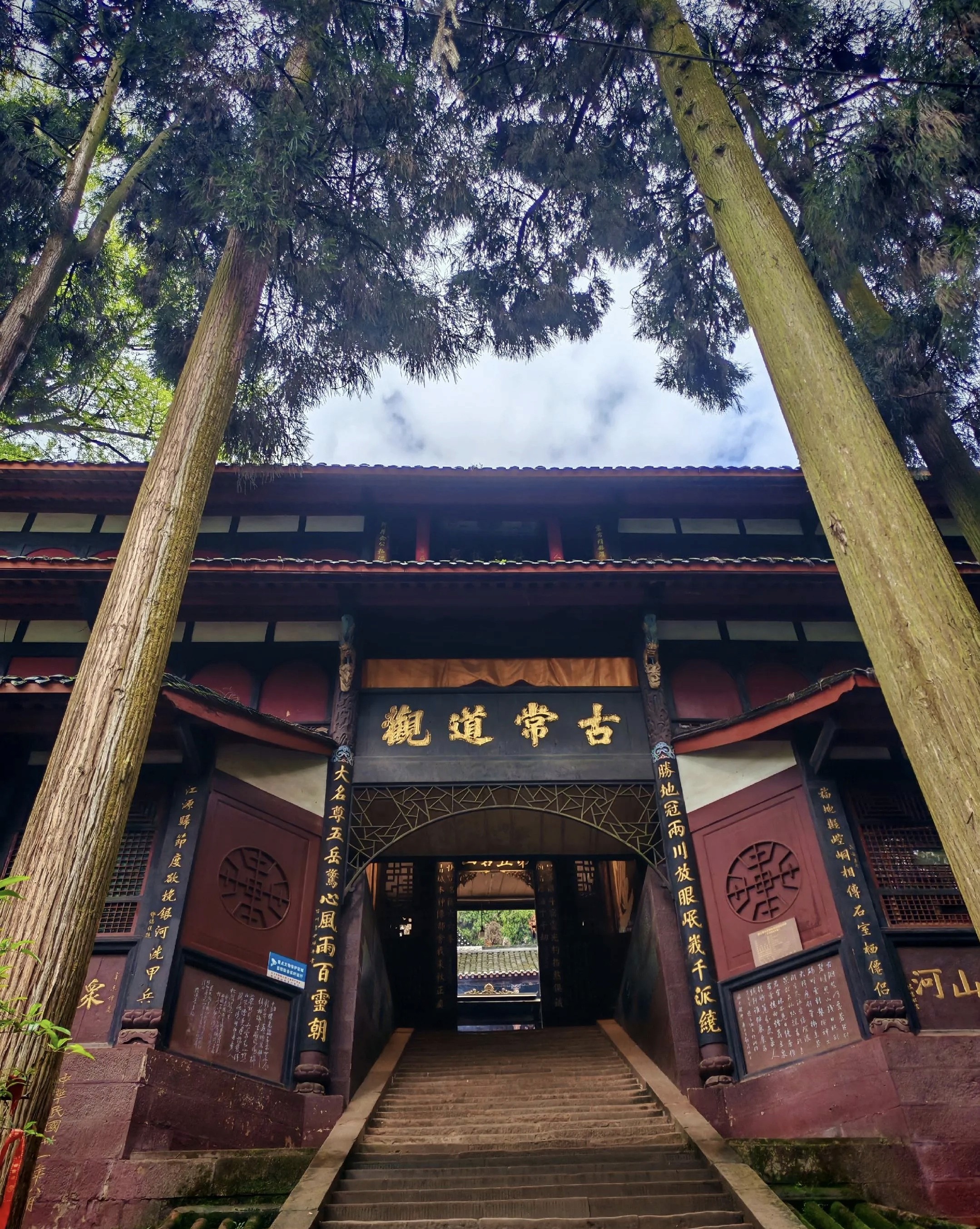 Ancient Changdao Taoist Temple gate surrounded by tall cedar trees, Qingcheng Mountain