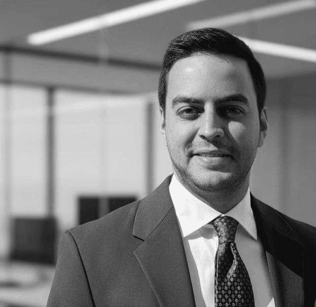 Man in suit with arms crossed smiling