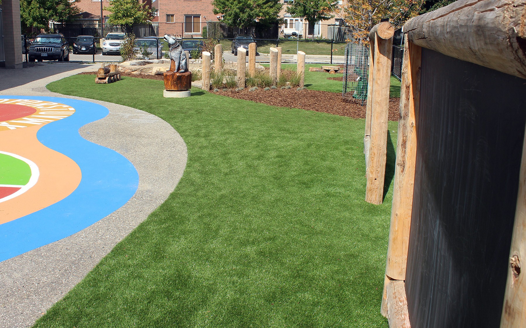 A colorful chalk-drawn playground surrounded by artificial AGL Grass.