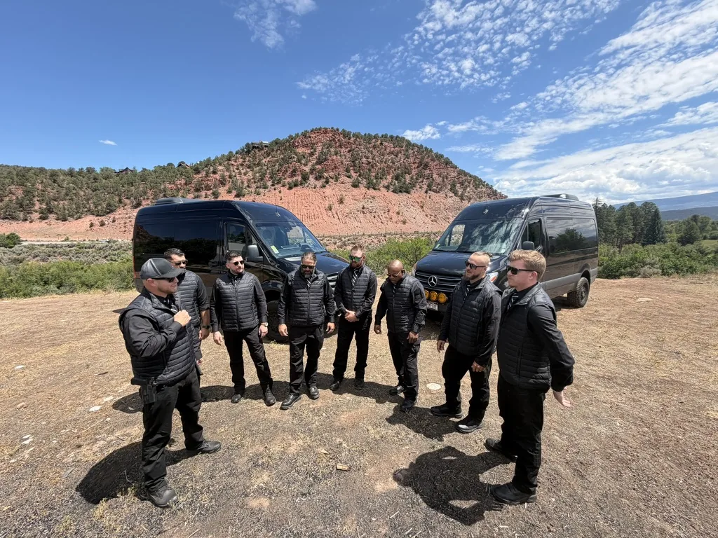Detail leader briefing the protective team beside two Mercedes Sprinters