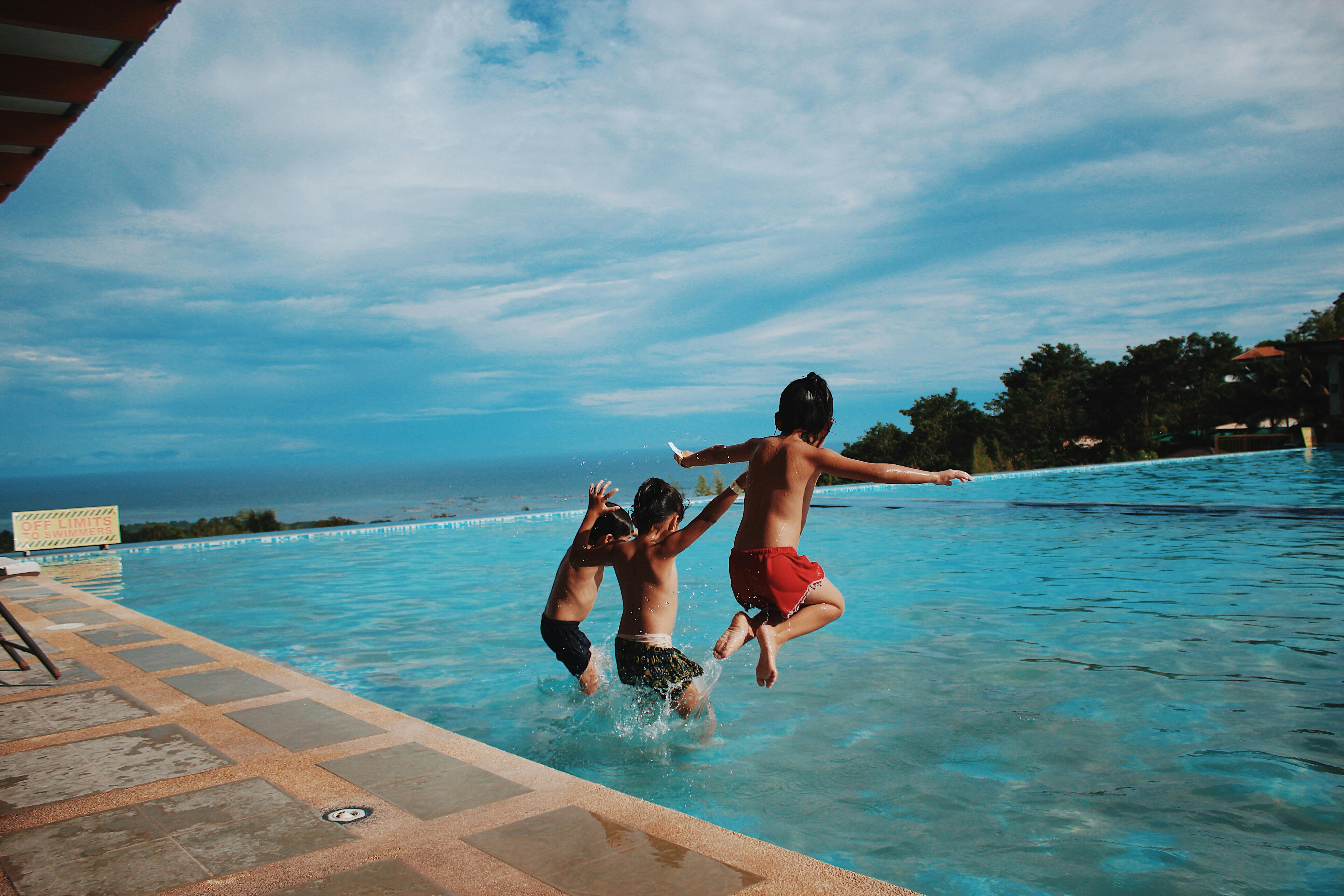 Kids jumping into a swimming pool