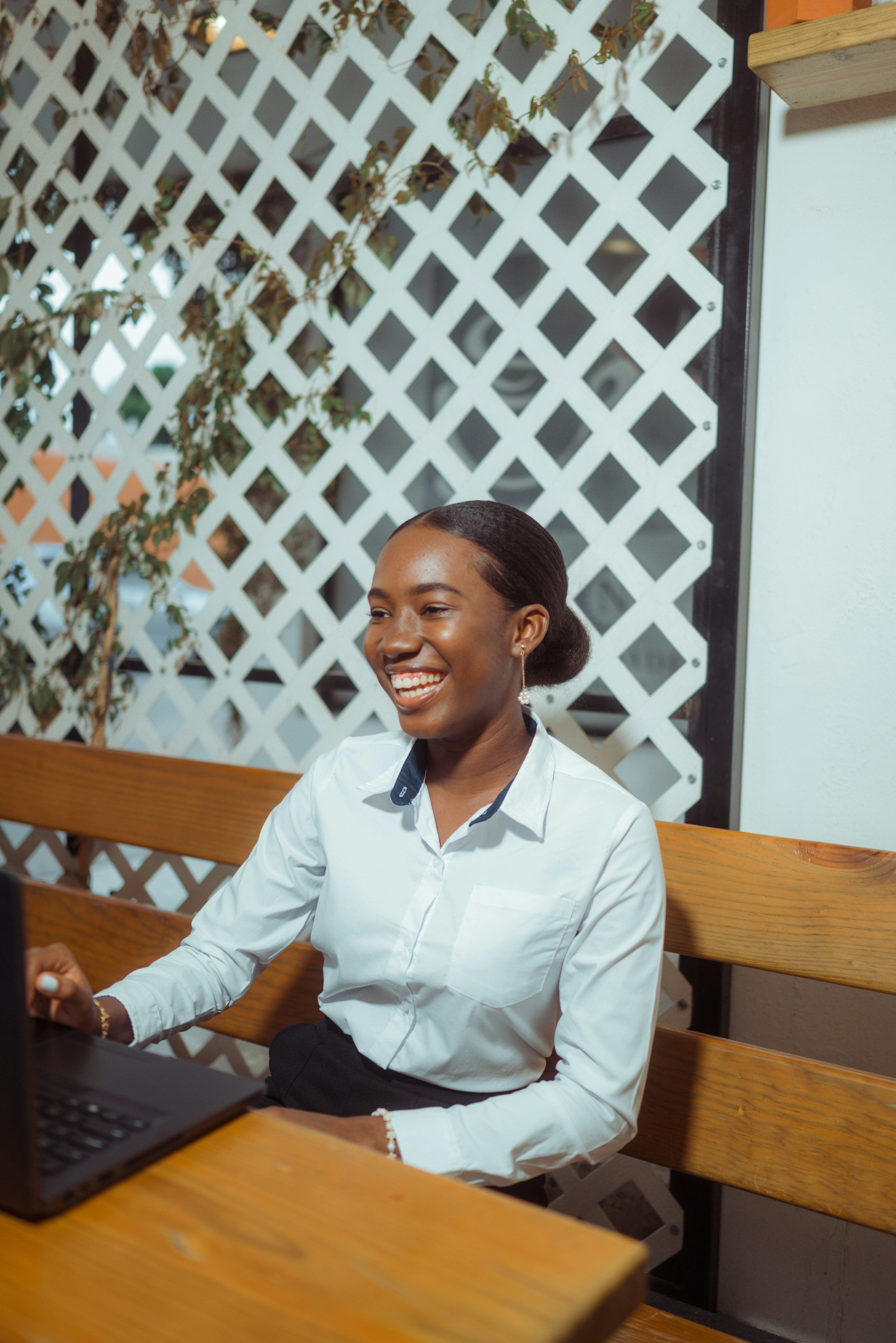 Young woman smiling while working on laptop.