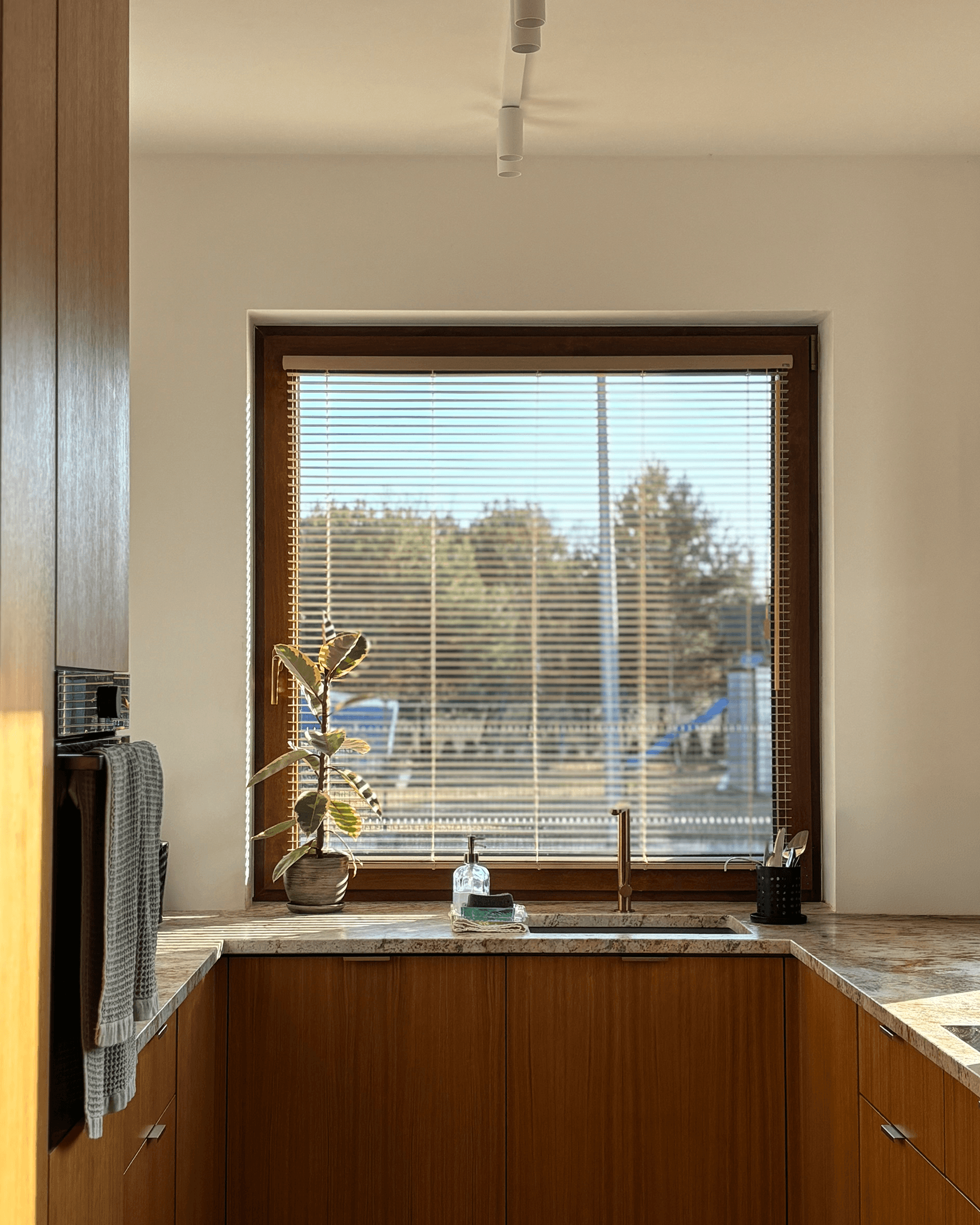 Precyzyjnie dopasowane żaluzje aluminiowe w kuchni nad zlewem. Montaż osłon okiennych HeyShade w Pruszkowie – ochrona przed słońcem i prywatność w strefie zmywania.
