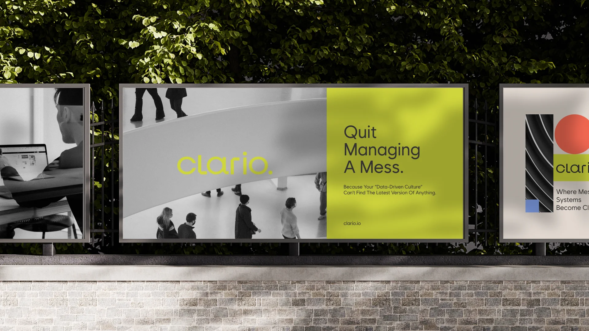 Outdoor fence-mounted ad featuring Clario's "Quit Managing A Mess" headline against black-and-white lifestyle photography and the citrus color block.