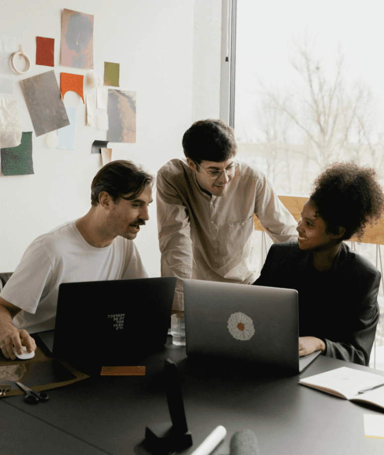 team of three people looking at laptops