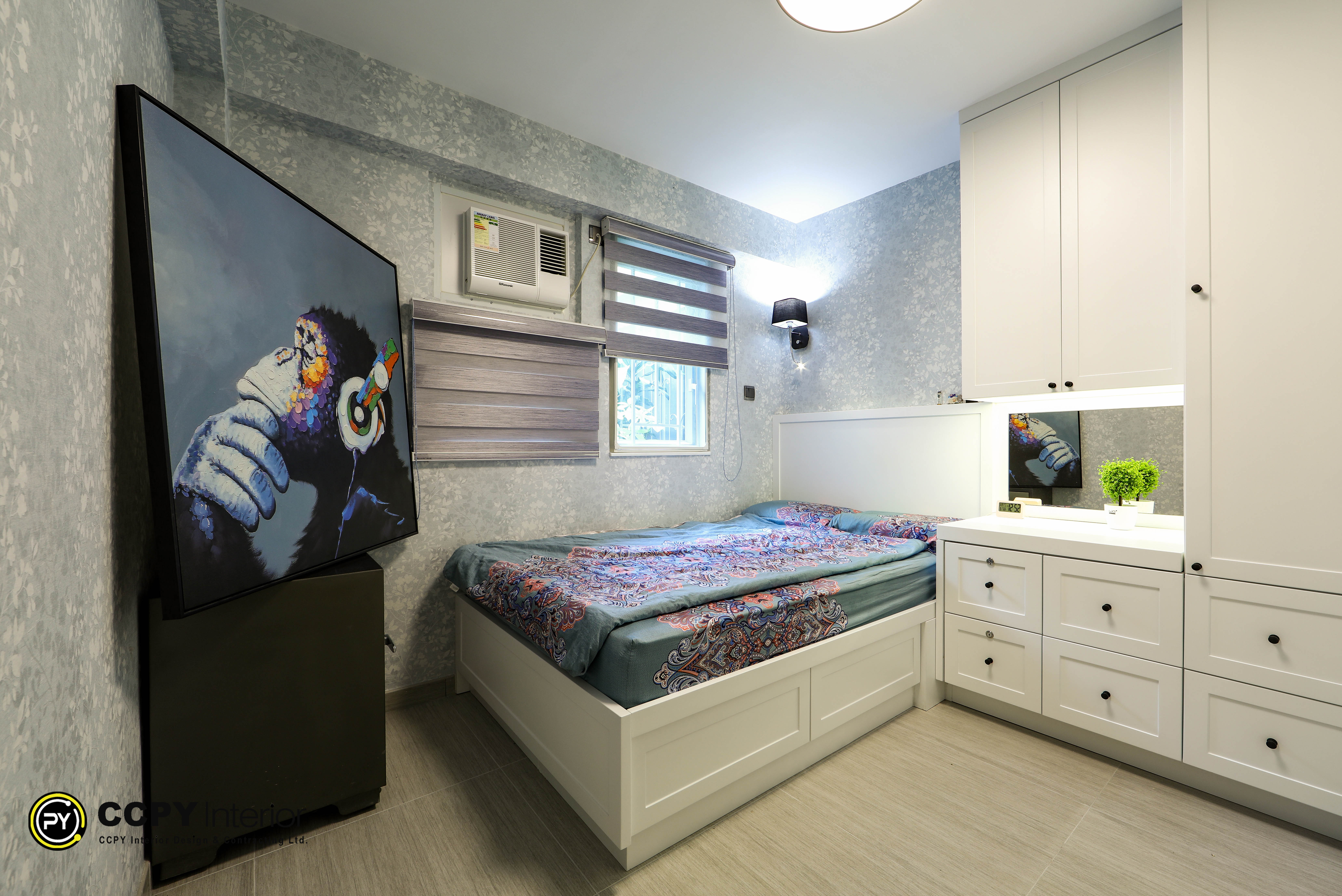 Master bedroom featuring a white custom wardrobe, floral wallpaper, contemporary monkey artwork, and grey roller blinds at Kwan Lok Sun Chuen.