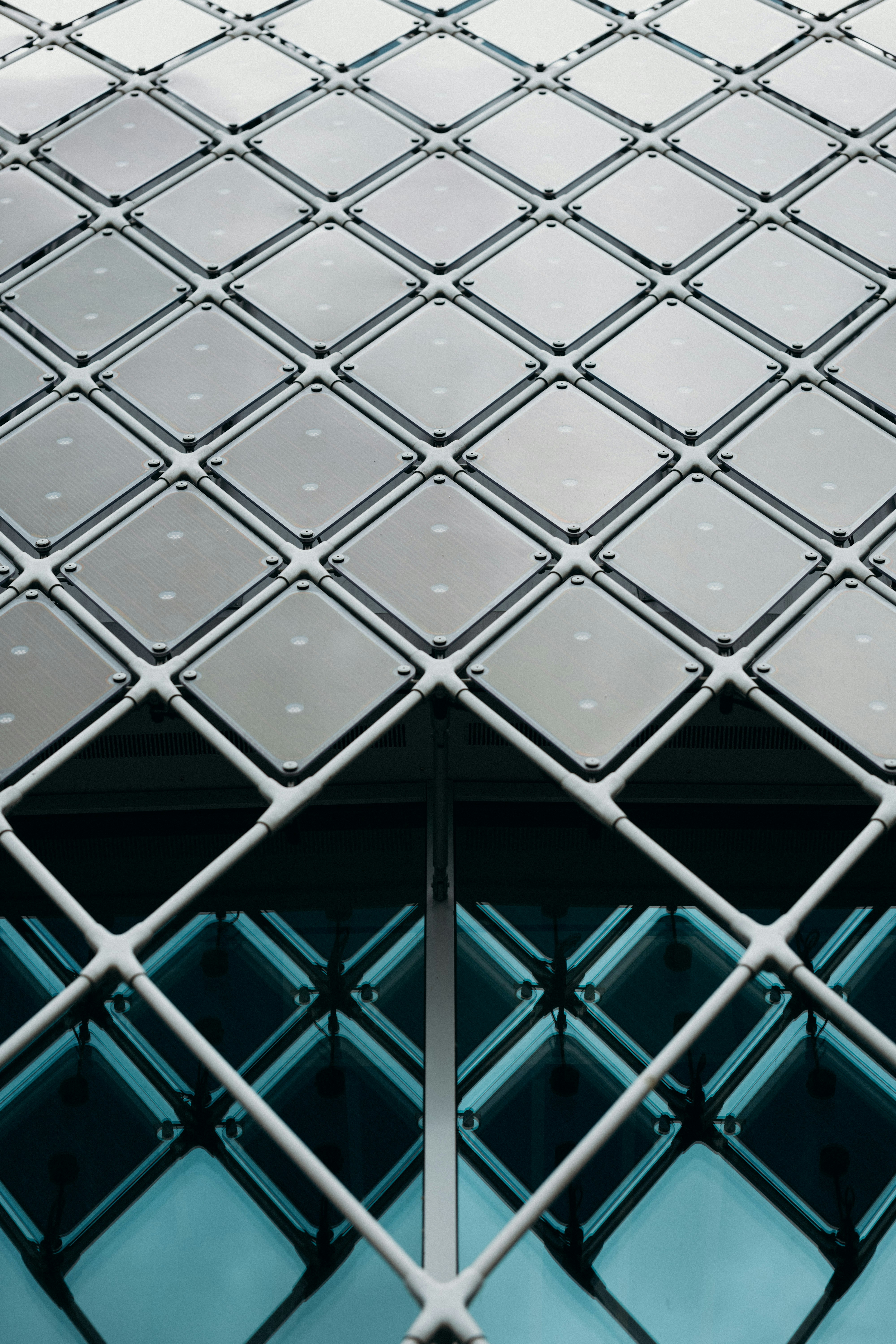 a close up of a metal fence with a building in the background