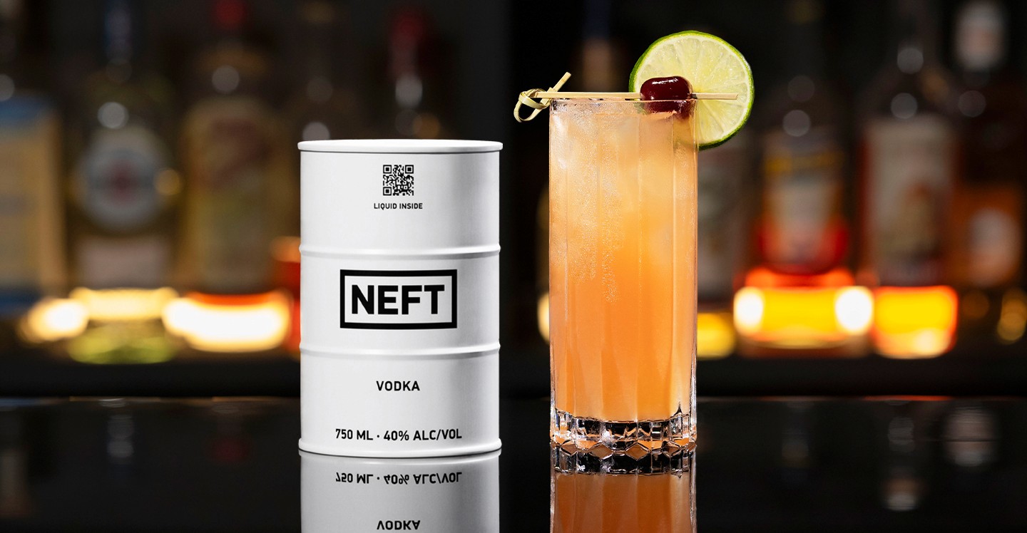 A NEFT Barrel and a glass of Bay Breeze on a bar counter.