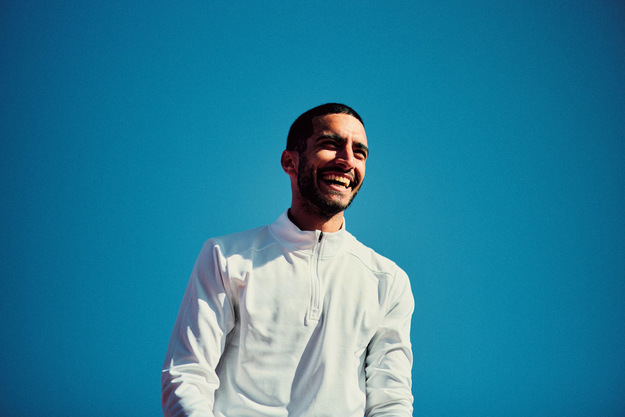 a plane flying through a cloudy blue sky