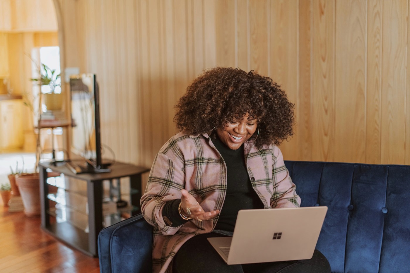 A woman smiling while using a laptop at home during a virtual appointment, reflecting personalized telehealth nutrition care with a registered dietitian.