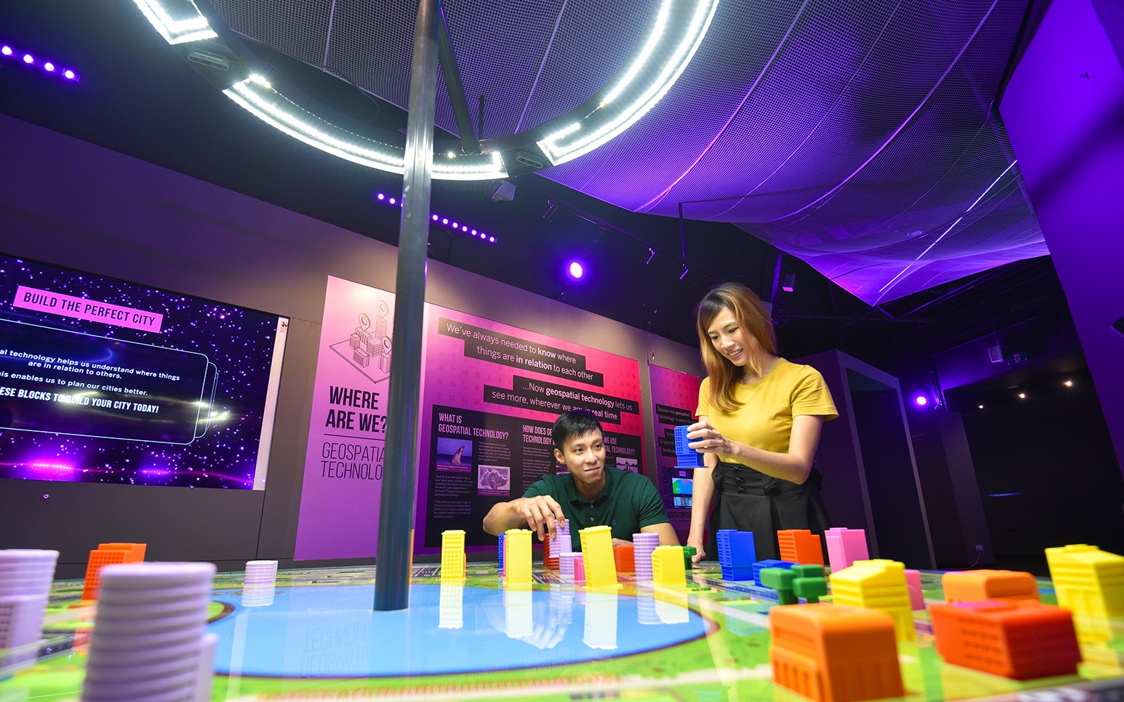 Interactive exhibit at Science Centre Singapore with visitors building a model city.