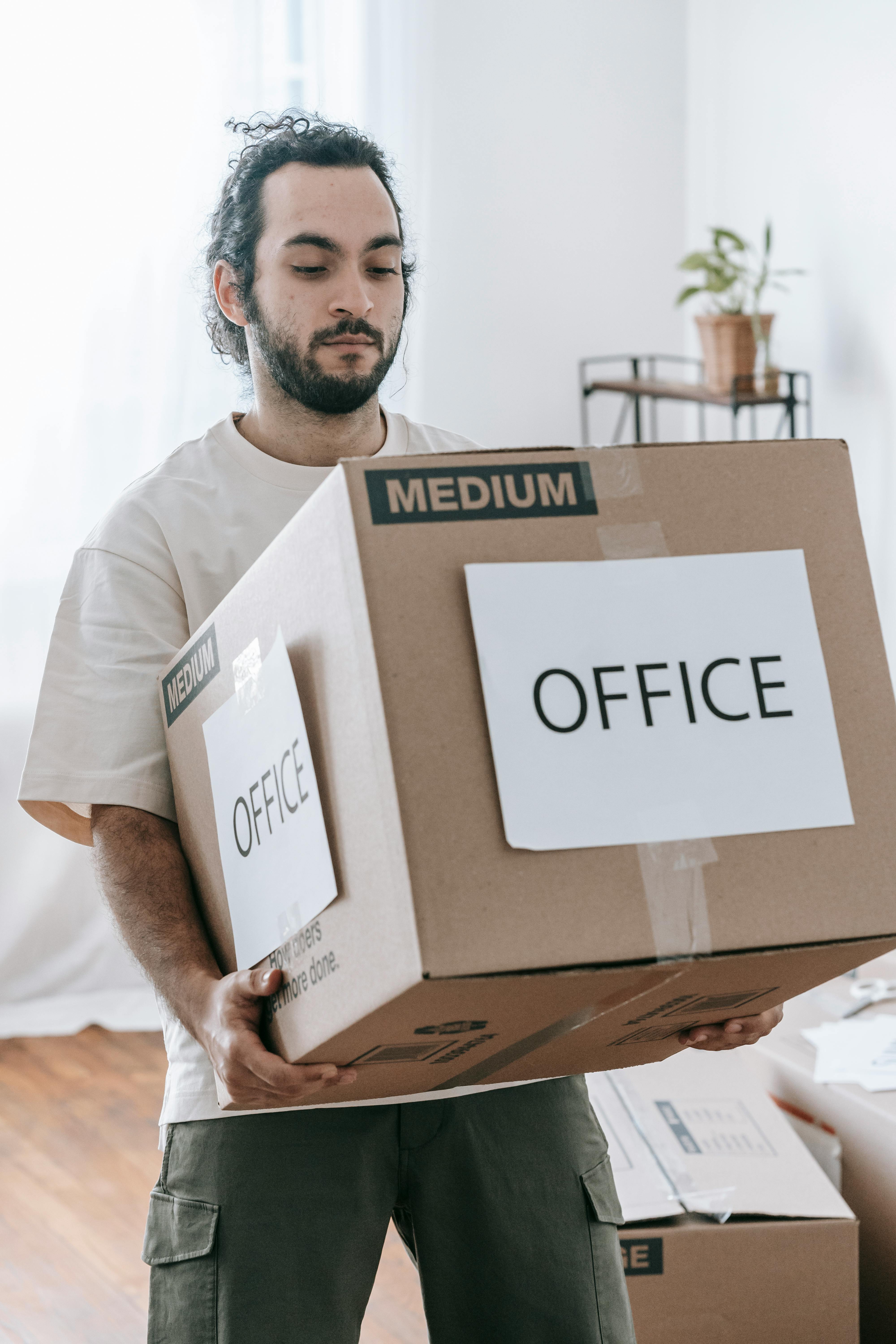 Man moving box labelled "office"