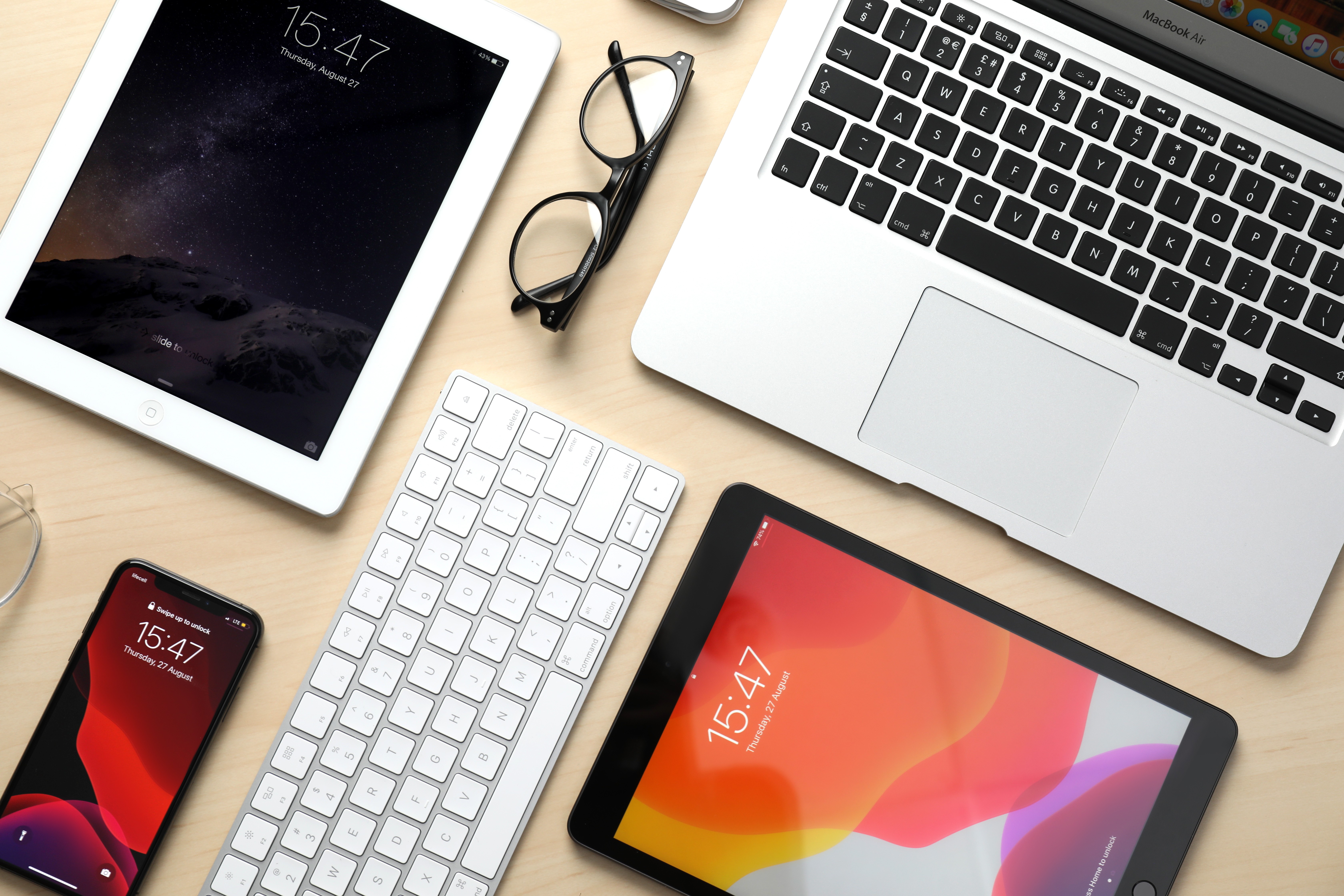 MacBook laptop and iPad tablets on wooden table