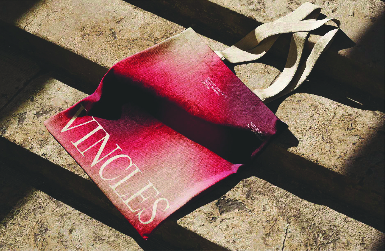 Branded tote bag design with soft gradient textures and refined typography inspired by wine tones