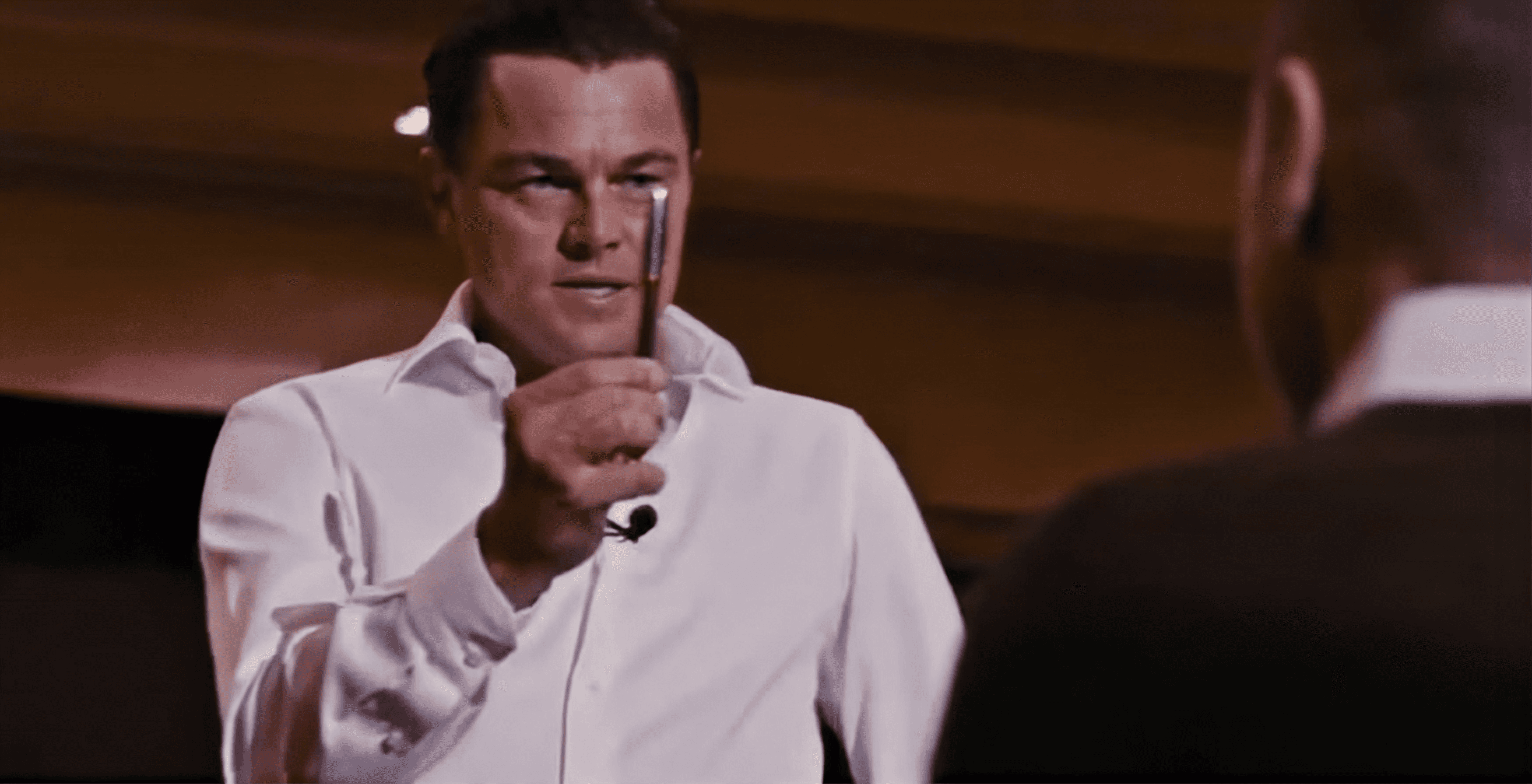 Jordan Belfort holding up a pen in The Wolf of Wall Street