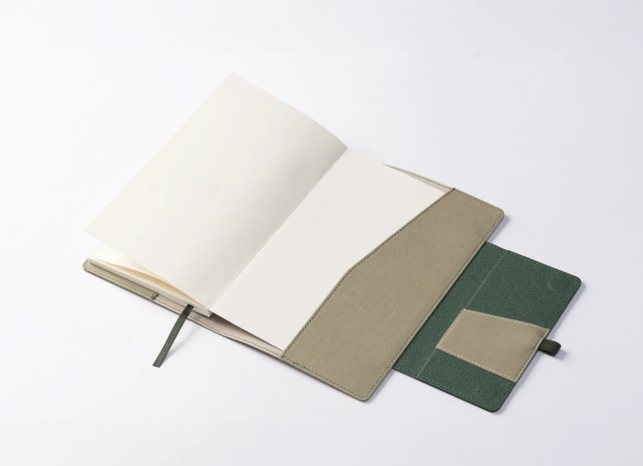 Open beige notebook with pages turning, revealing cover construction.