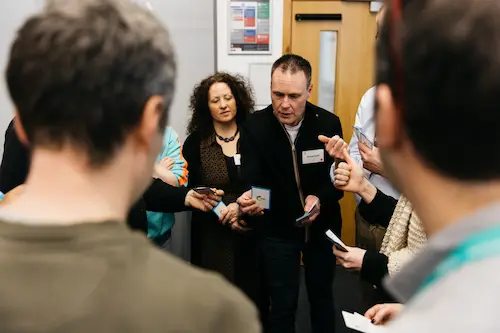 People standing and holding phones in a room.